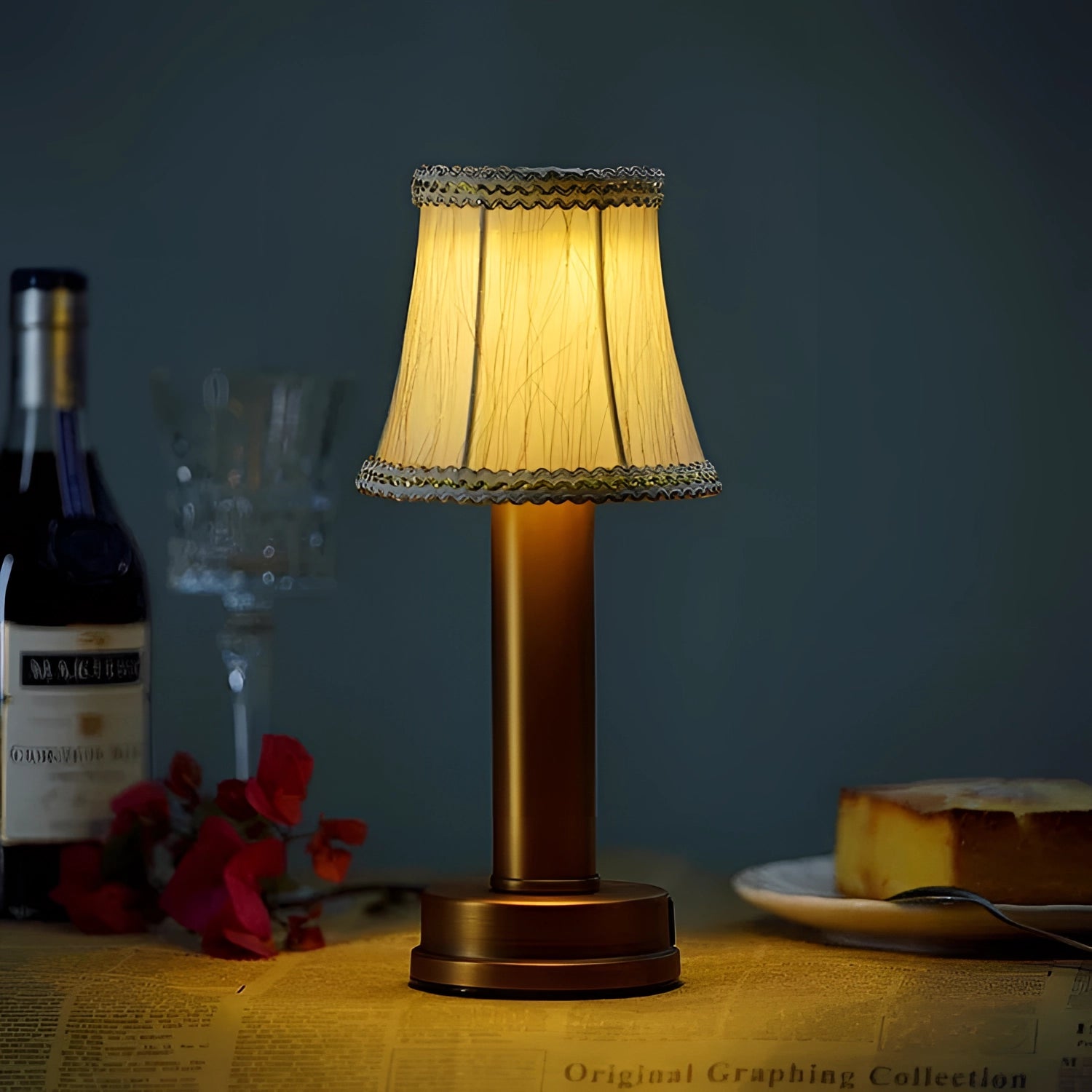 Elegant designer table lamp with a matt gold finish and black lace accents, positioned on a wooden table, showcasing its luxurious and sophisticated aesthetic, ideal for enhancing interior design.