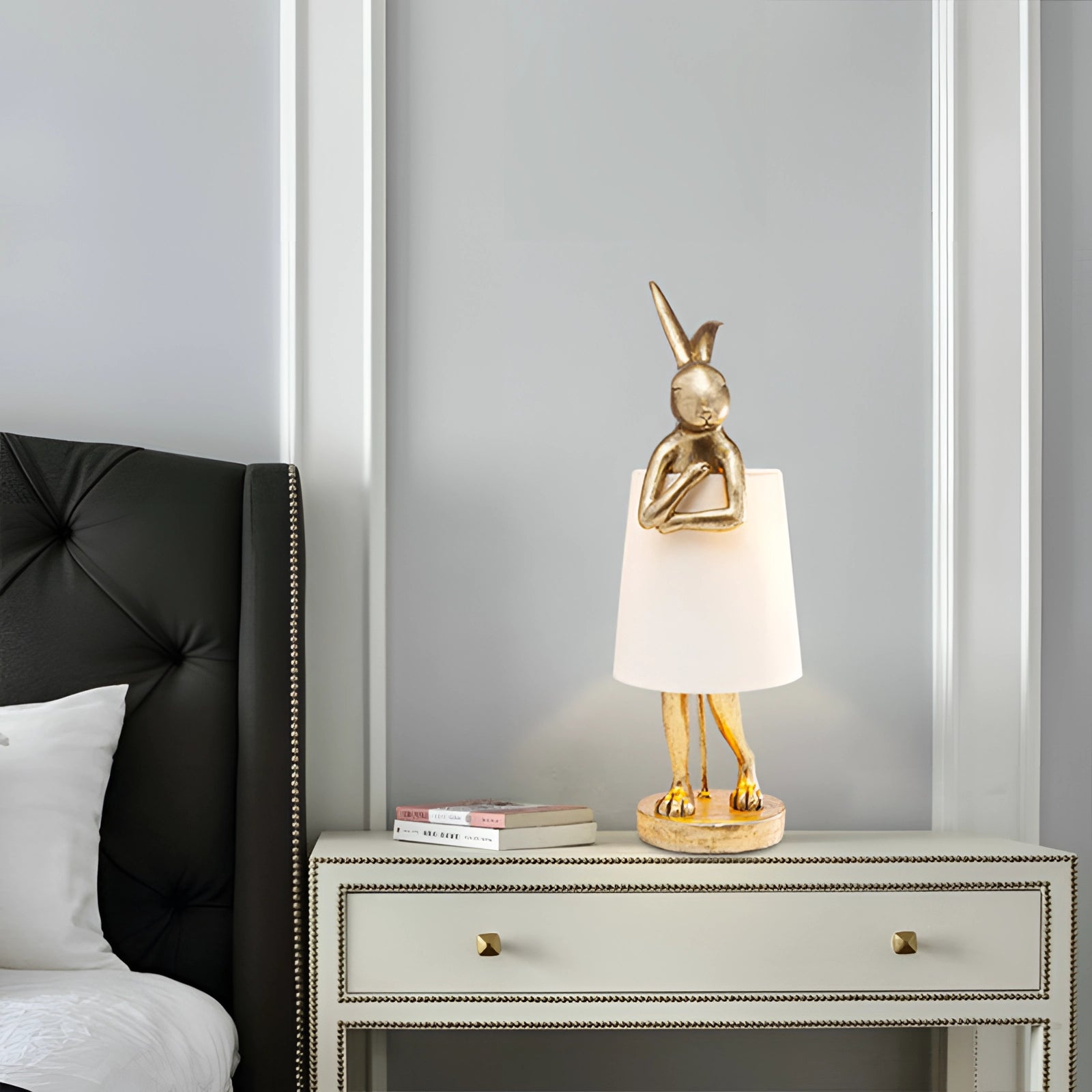 Luxurious gold rabbit lamp in the shape of a bunny, placed on a wooden shelf, surrounded by modern interior design elements, featuring warm, orange lighting.