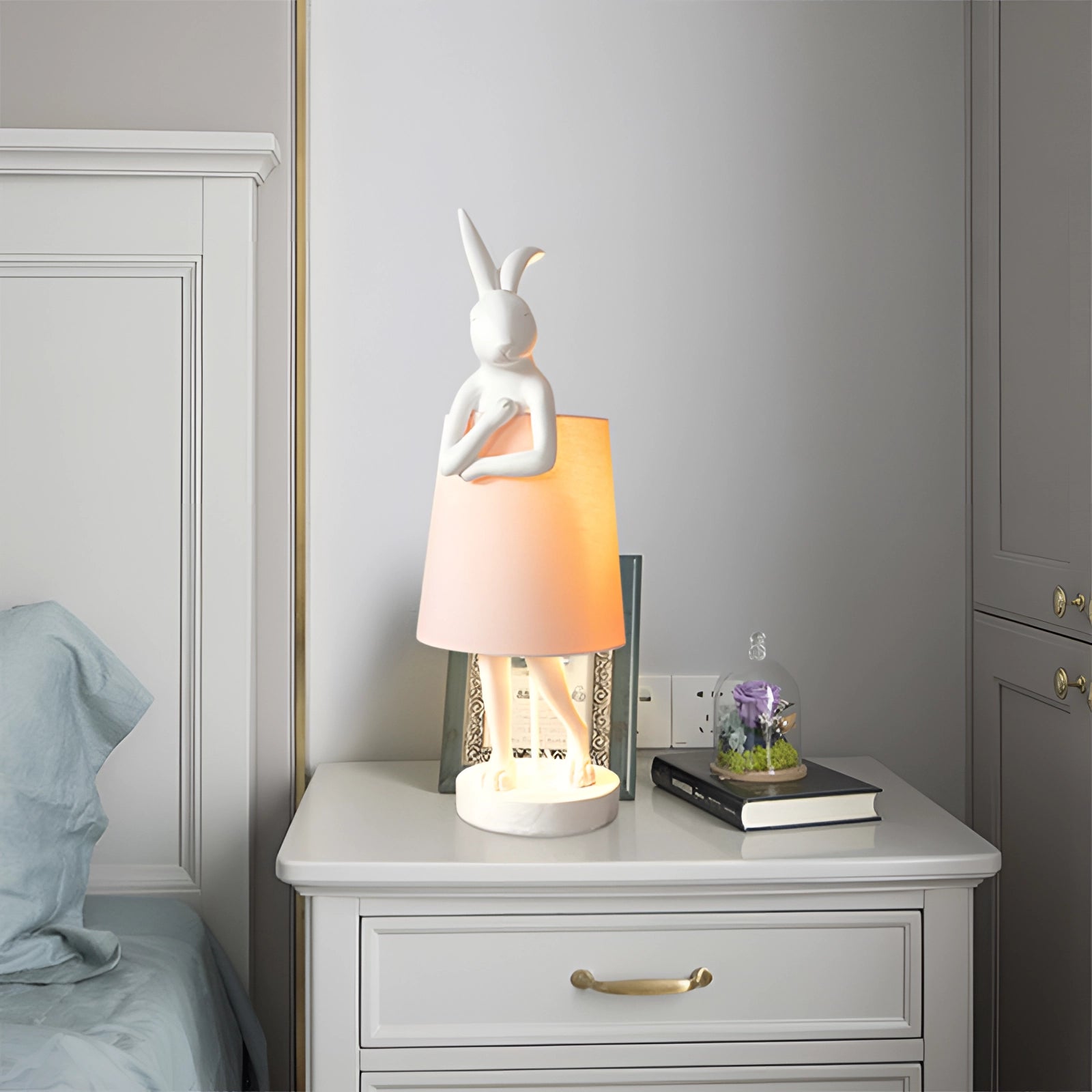 Gold Rabbit Lamp featuring a detailed bunny figurine, serving as an elegant lighting decor piece on a wooden shelving unit, in a modern interior setting with white and grey tones.