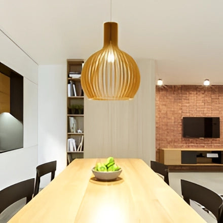 Golden wooden pendant light hanging above a modern dining room setting, featuring wooden furniture and contemporary interior design elements.