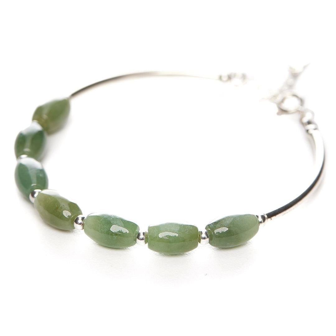 Silver bracelet featuring an oval-shaped green jade stone, highlighting its natural beauty and elegant craftsmanship.