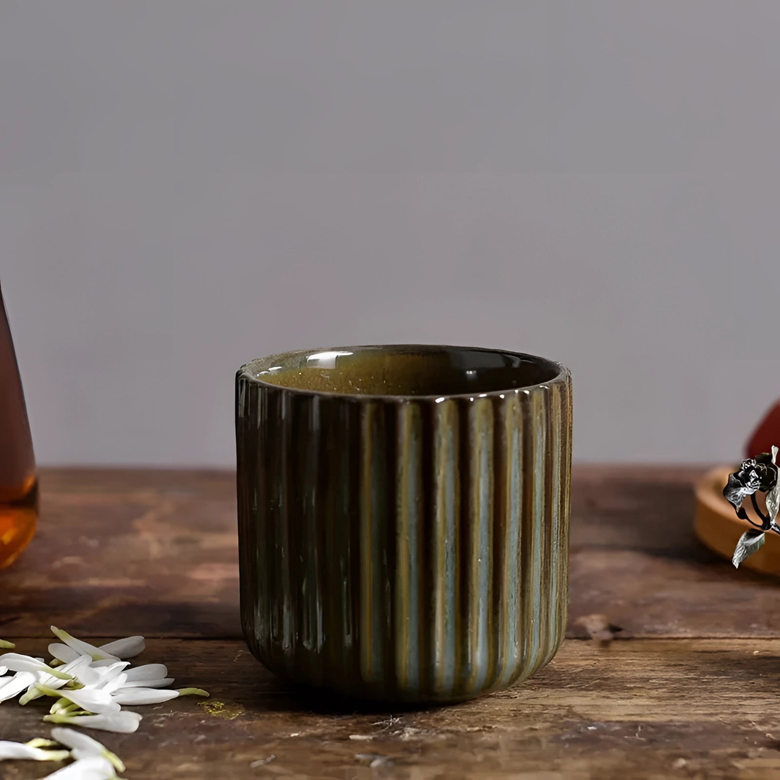 Handmade artisan stoneware green ribbed ceramic mug with a unique design, holding 180ml, displayed on a wooden table.