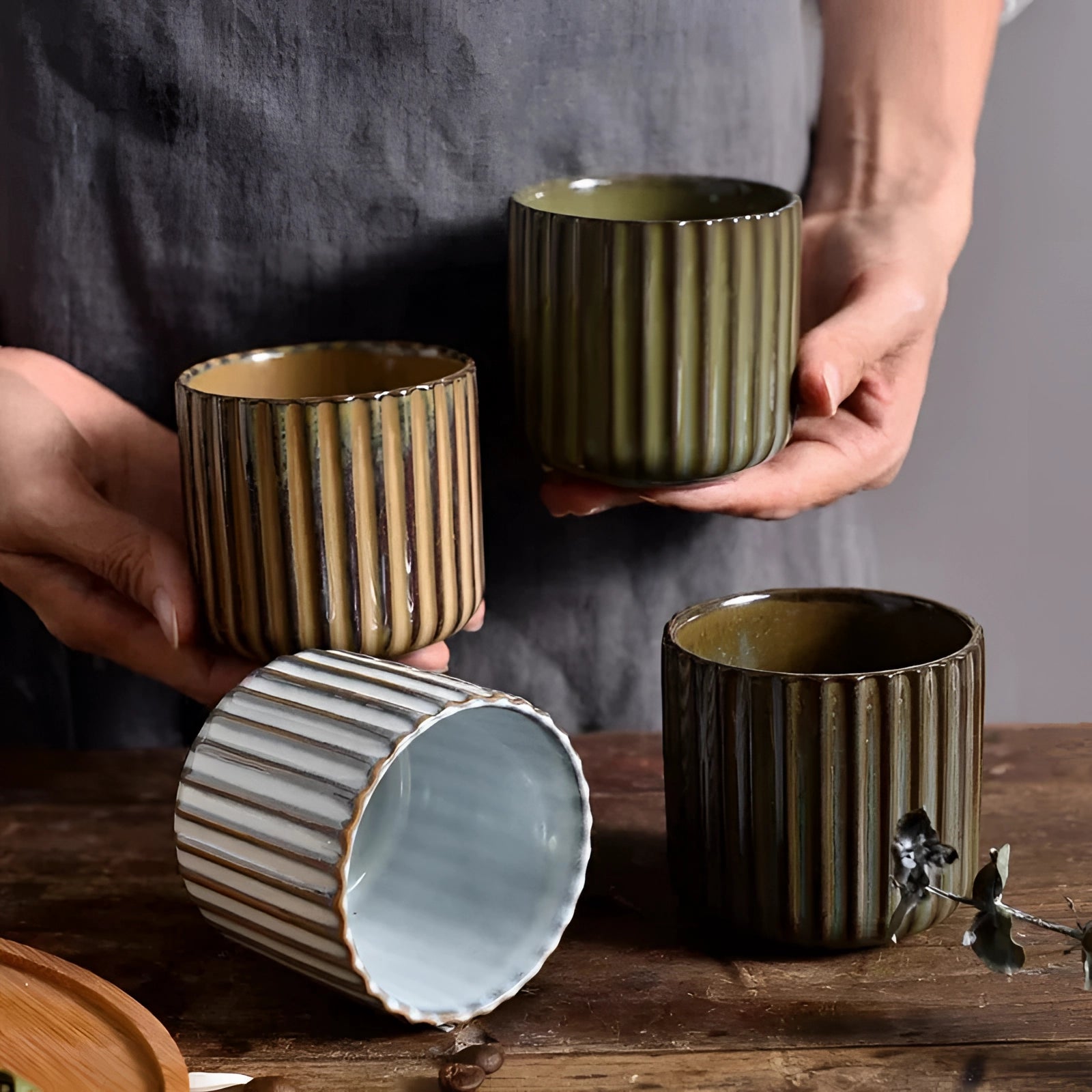 Handmade green ribbed ceramic mug crafted from artisan stoneware, displayed on a wooden surface.