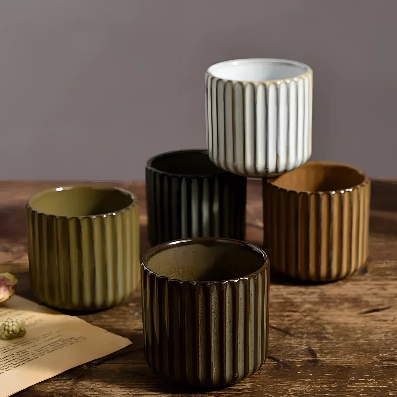 Handmade artisan stoneware mug with a green ribbed ceramic design, displayed on a wooden surface.