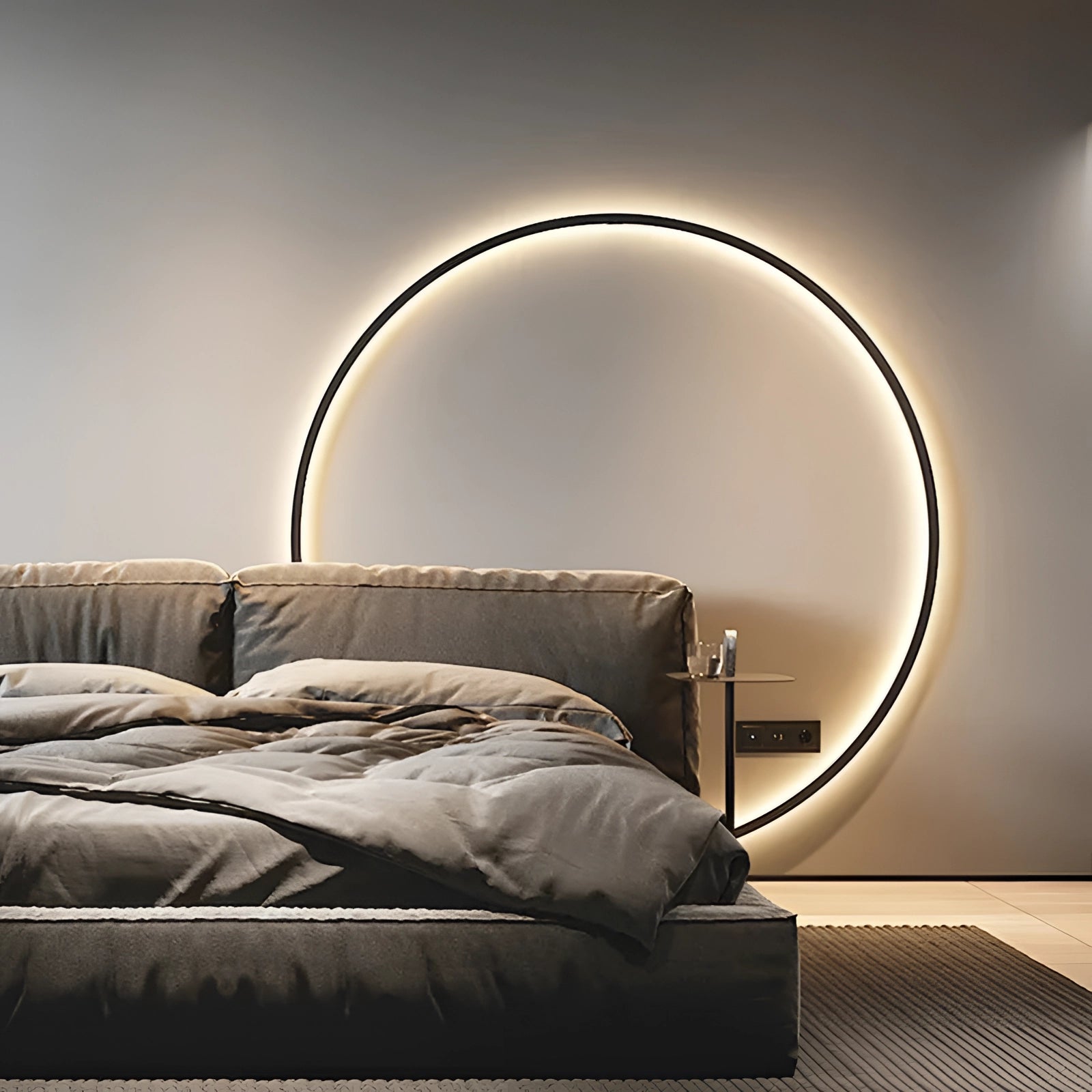 Large LED wall light with a minimalist modern design, featuring a 30cm cool white light. The lamp is mounted on a wall with a USB Type B input, set against a background of brown and grey furniture with wooden elements, creating a comfortable and ambient bedroom decor.