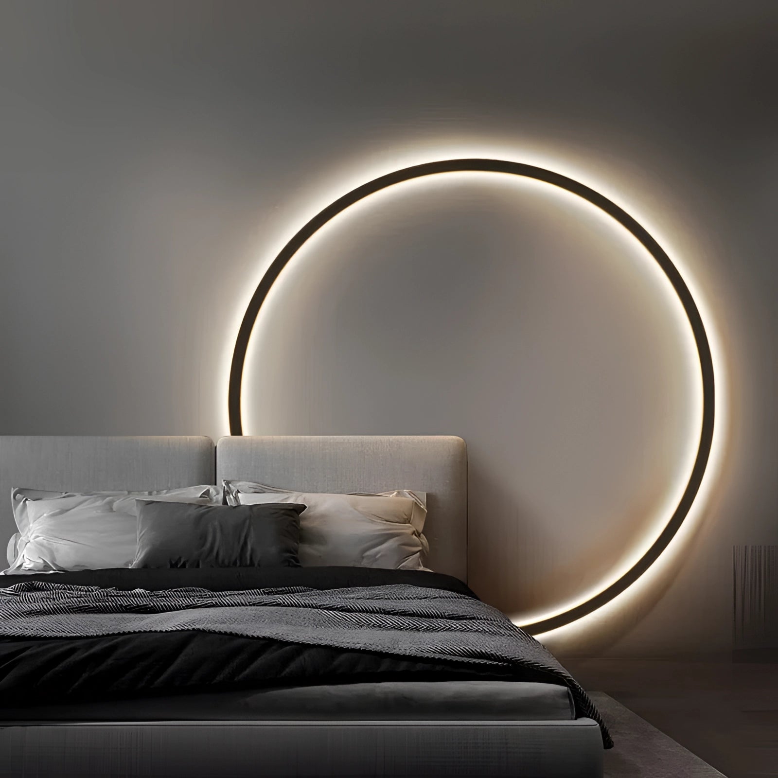 Large LED wall light with a minimalist modern design, mounted above a grey bed frame, creating ambient lighting in a stylish bedroom with wooden flooring.