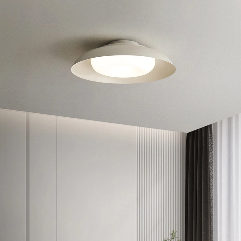 LED ceiling light with a modern minimalist round panel design, mounted flush to the ceiling, emitting soft-white light.