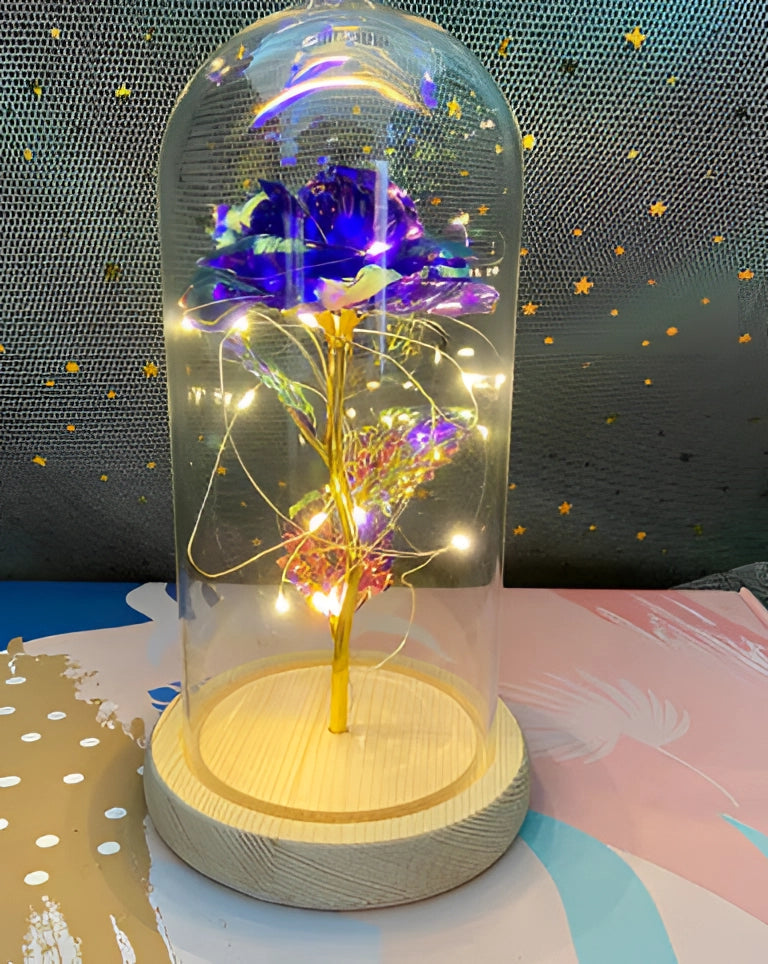 Enchanted LED rose dome featuring a purple rose illuminated by delicate fairy lights, set on a table as a decorative piece for interior design.