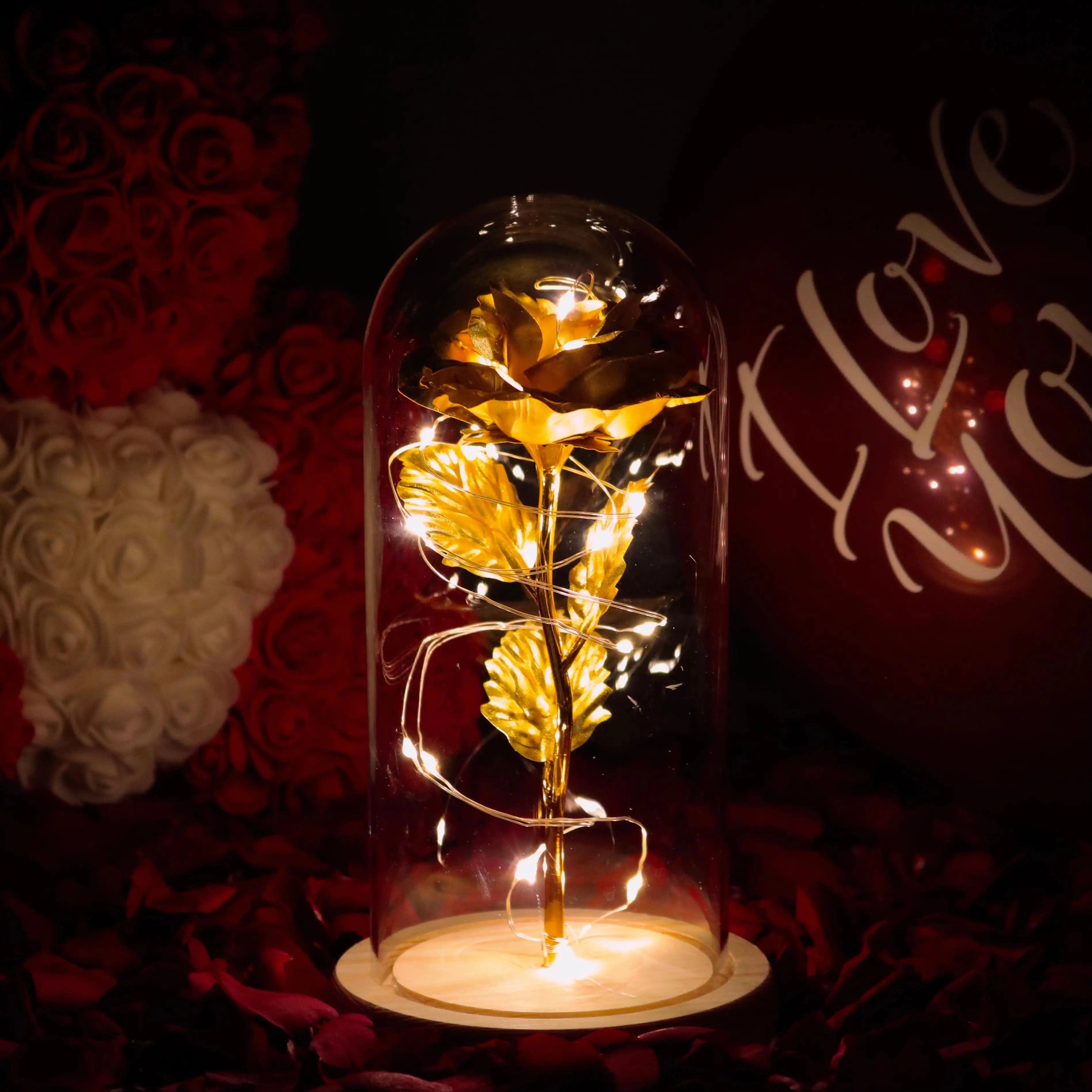 
A 24 Karat Gold LED Rose Dome featuring an illuminated enchanted rose with fairy lights, set within a glass dome. The warm amber lighting creates an artistic and elegant atmosphere, perfect for decoration and special events.