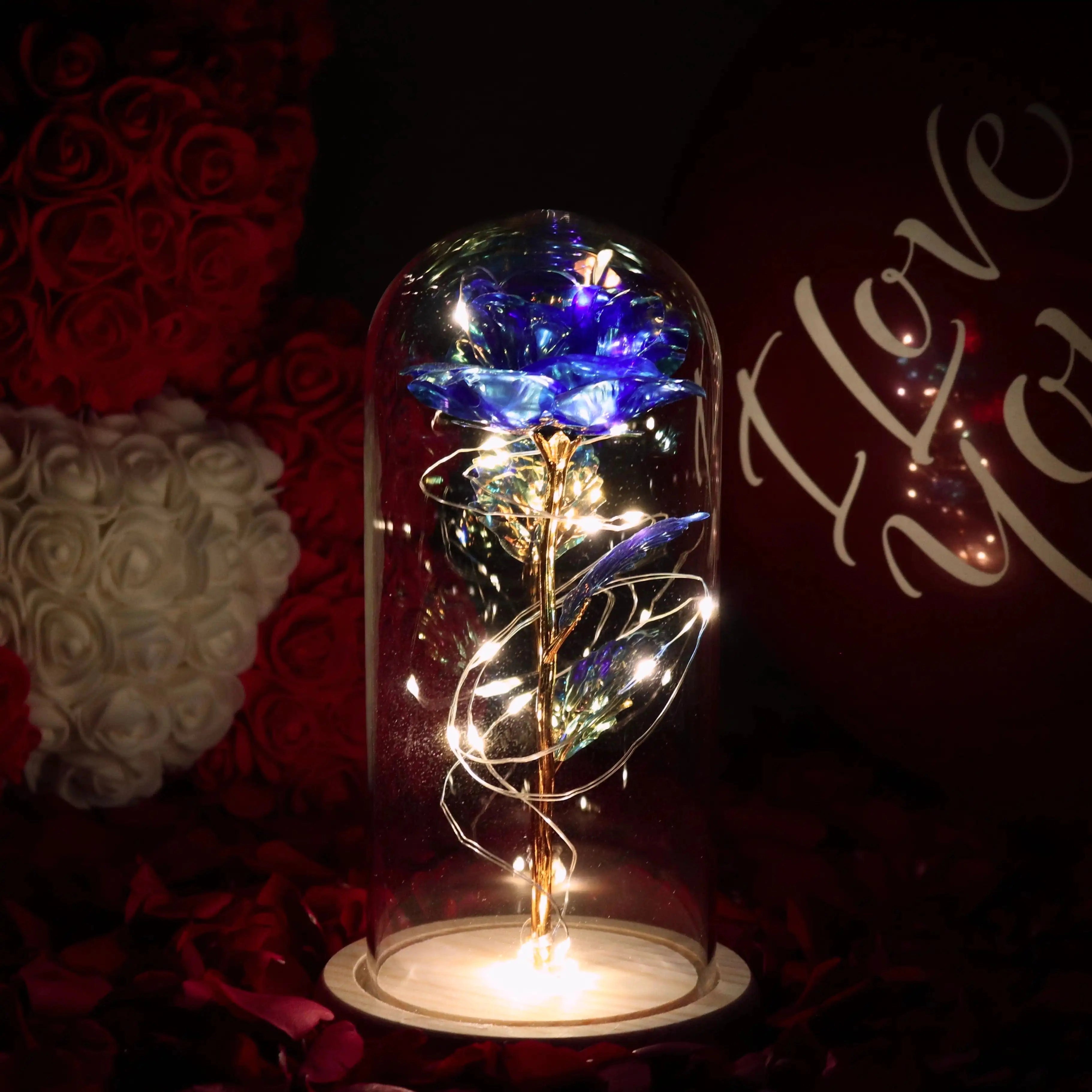 
A sapphire blue LED rose dome with enchanted rose light and fairy lights, showcasing a captivating electric blue glow inside a sleek glass dome, set against a dark background.