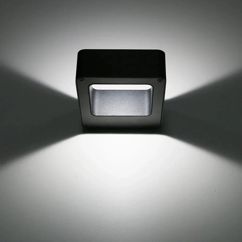 Modern square-shaped LED wall sconce with a weather-resistant exterior, designed for outdoor use, featuring a sleek and contemporary appearance.