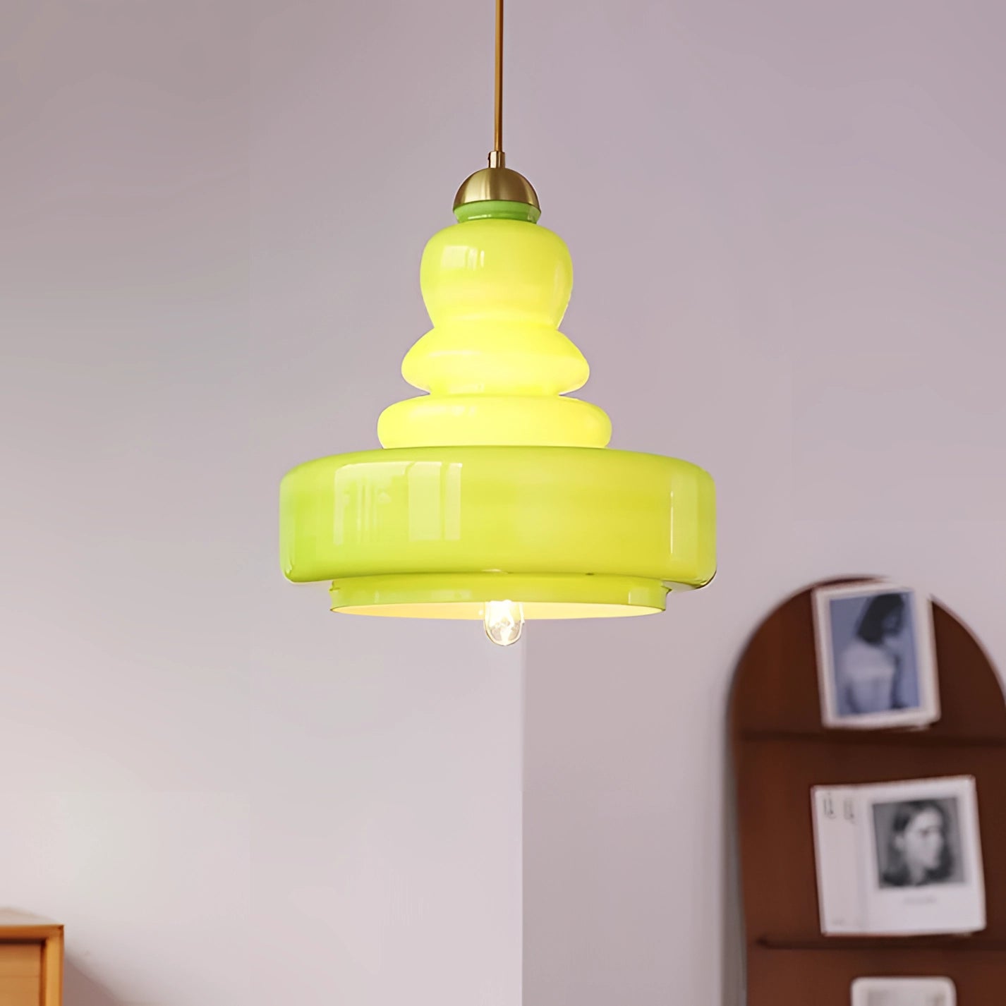 Lime green modern pendant light with tiered glass and brass design, hanging from the ceiling, showcasing Scandinavian style ideal for kitchen interiors.