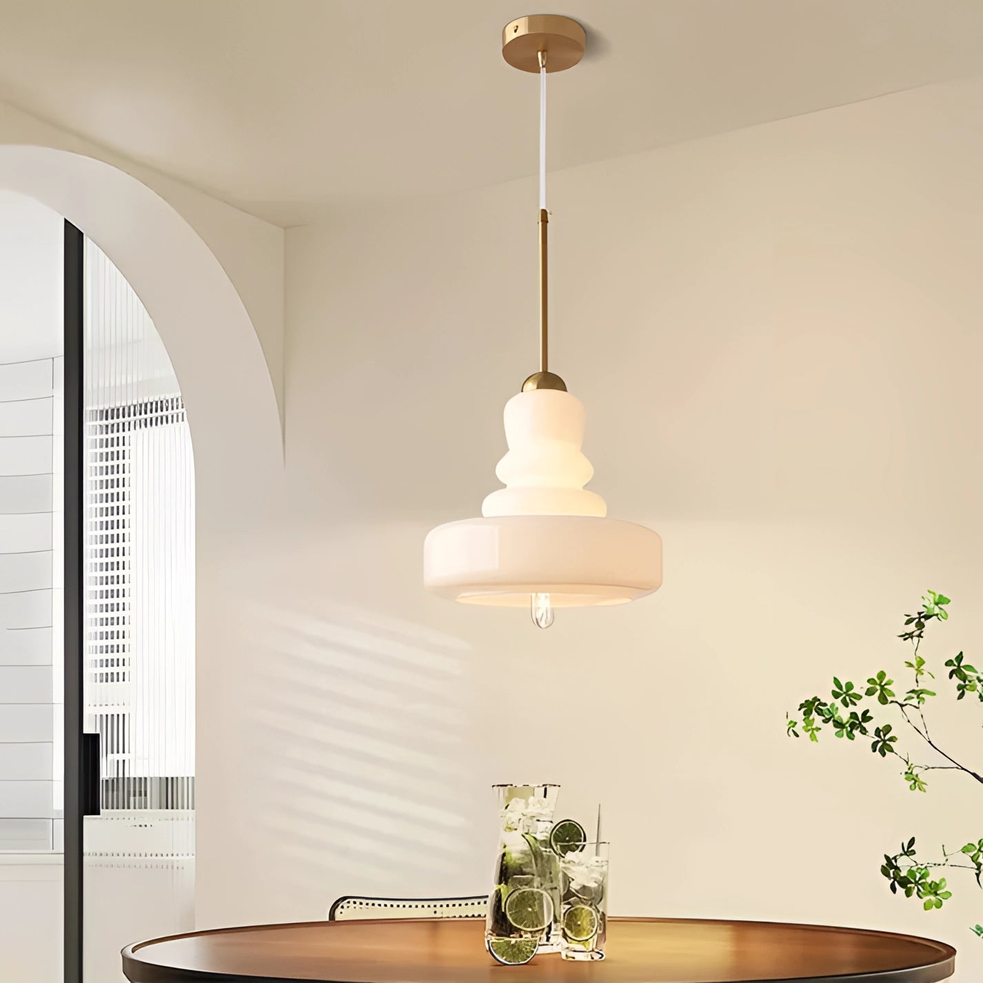 Lime green modern pendant light with a tiered design, featuring a white glass and iron shade, hanging above a wooden table in a Scandinavian-style kitchen interior.