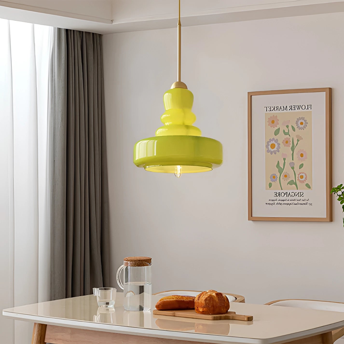 Lime green modern pendant light with tiered design hanging above a wooden kitchen table with tableware.