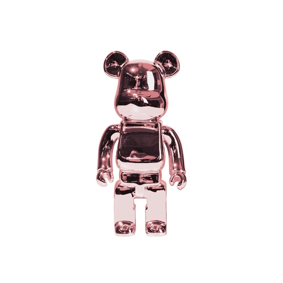 
A clear vinyl bearbrick art toy figurine with a gold rose design, showcasing a glossy finish and intricate detailing, resembling a fictional character with designer aesthetics.