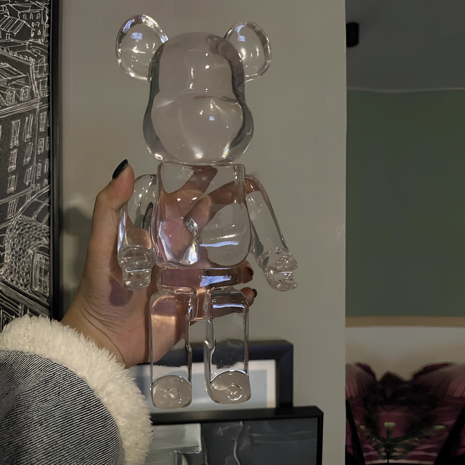 Limited Edition Clear Vinyl Bearbrick Designer Art Toy Figurine displayed in a stylish setting with a picture frame backdrop, showcasing transparent material and fashion design elements.