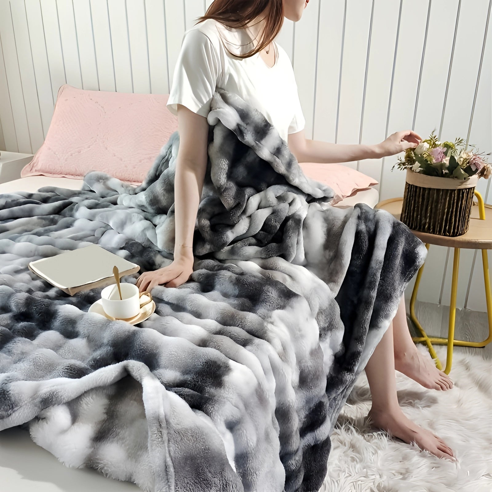 Luxurious gray faux fur blanket draped over a cozy bed, measuring 200 x 230 cm, with a soft plush texture and elegant pattern, enhancing the room's decor alongside a nearby houseplant.