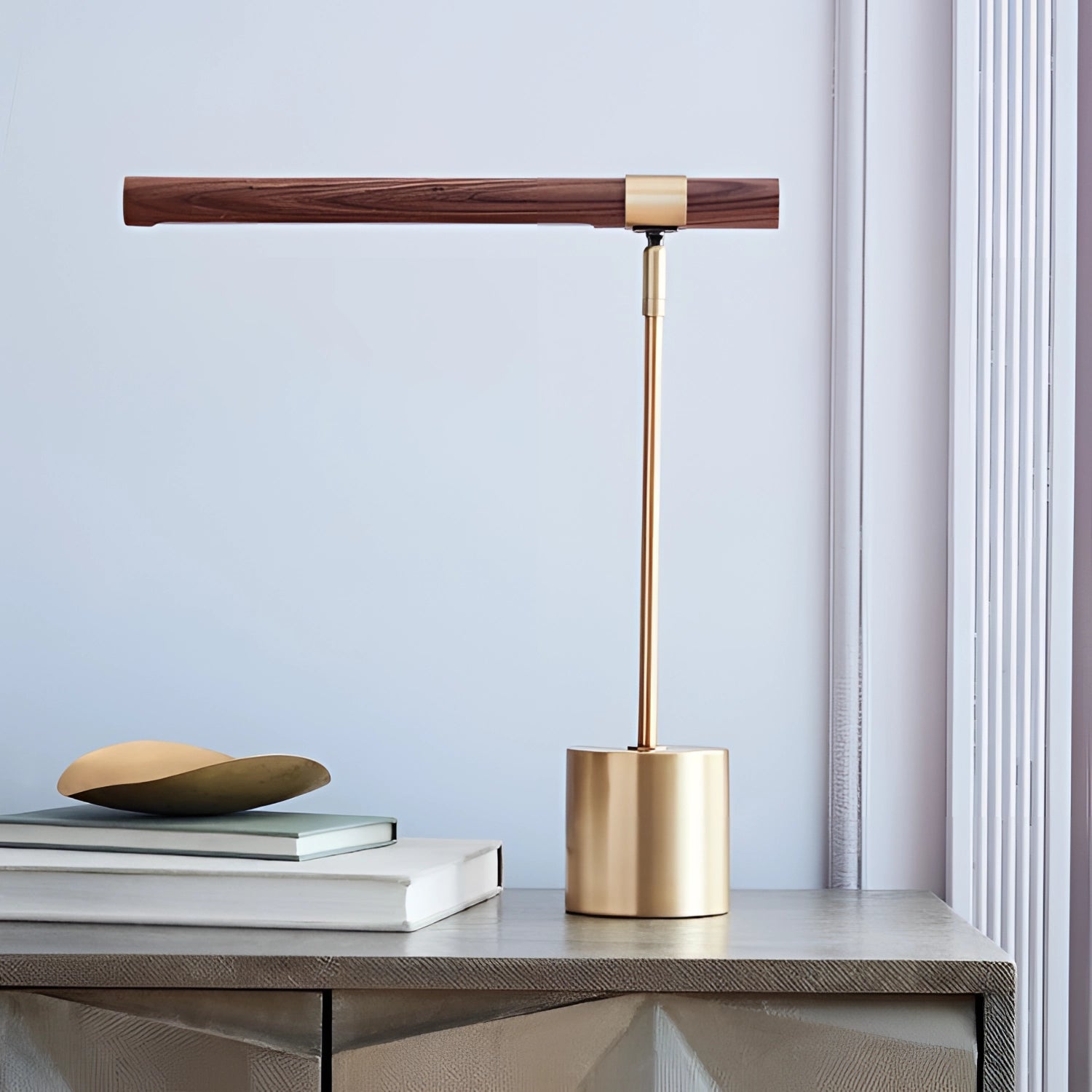 Luxury brass and wood adjustable desk lamp on a wooden shelf, featuring modern office lighting design with hardwood elements.