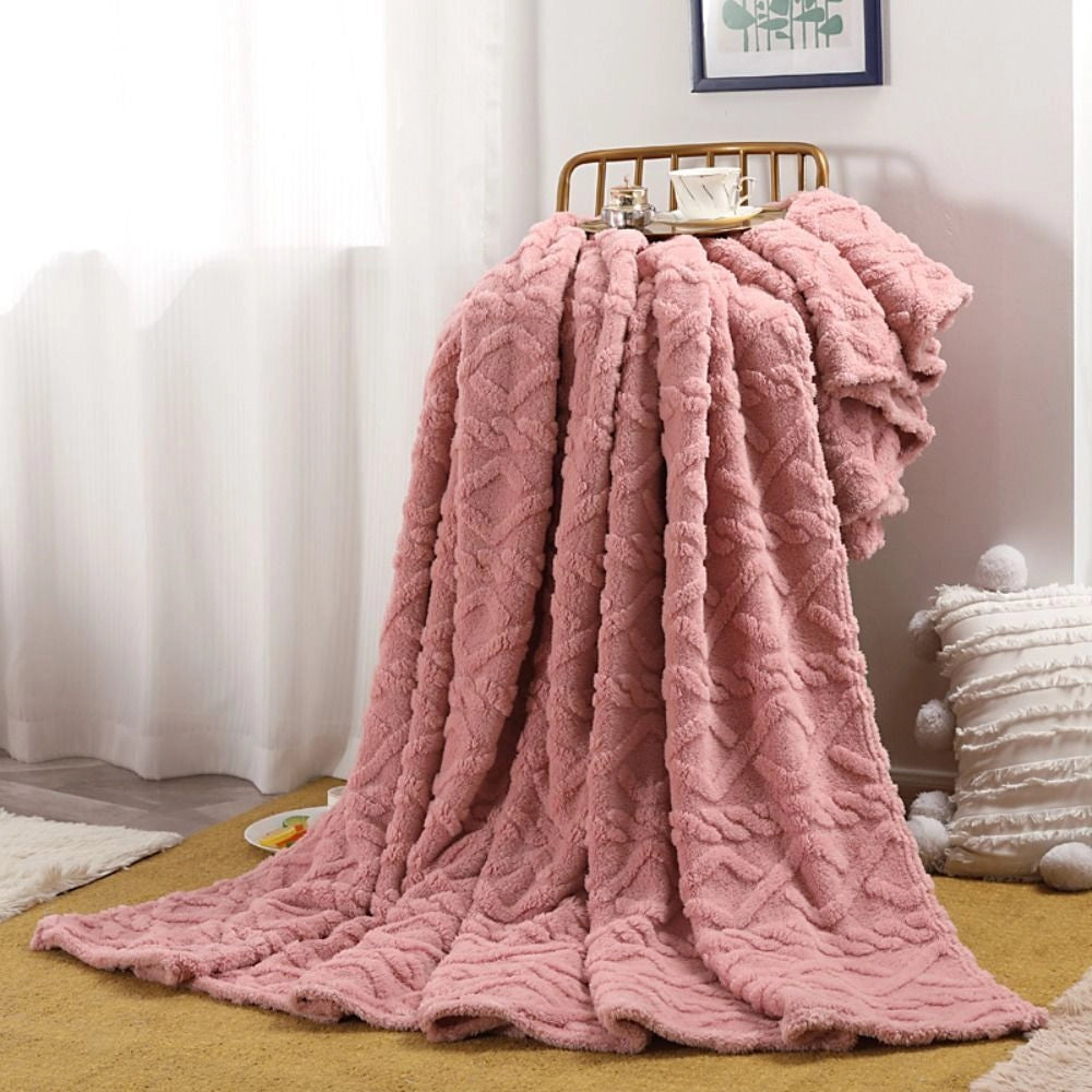 Luxurious pink cable knit throw blanket measuring 200x230cm, draped elegantly over a wooden clothes hanger, set against a cozy interior design backdrop.