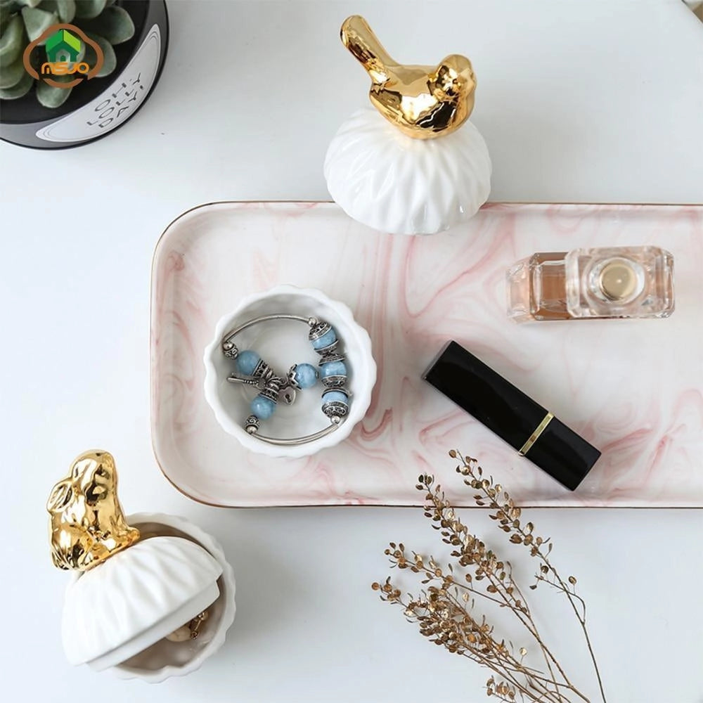 Luxury ceramic squirrel-shaped box with a gold lid, used as a jewelry holder. The box is predominantly white with artistic details, showcasing its decorative and functional design.