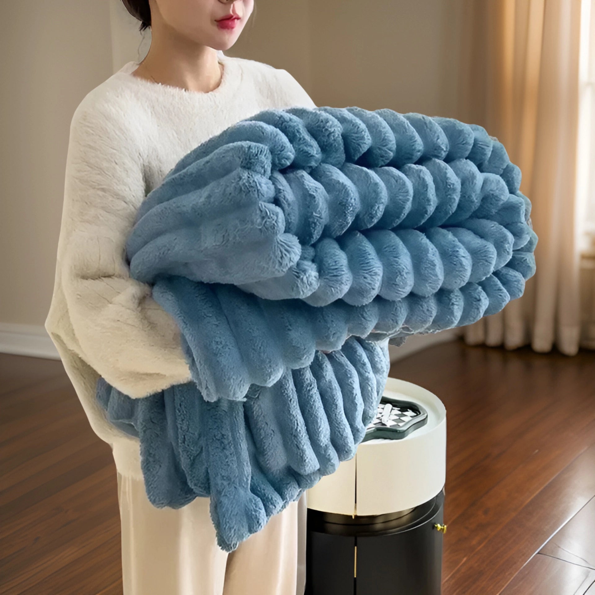 
A luxurious chunky knit blanket in a soft, plush texture draped over a person's shoulder, showcasing its size in the blue color variant, measuring 200x230cm. The blanket complements modern decor with its rich azure hue.