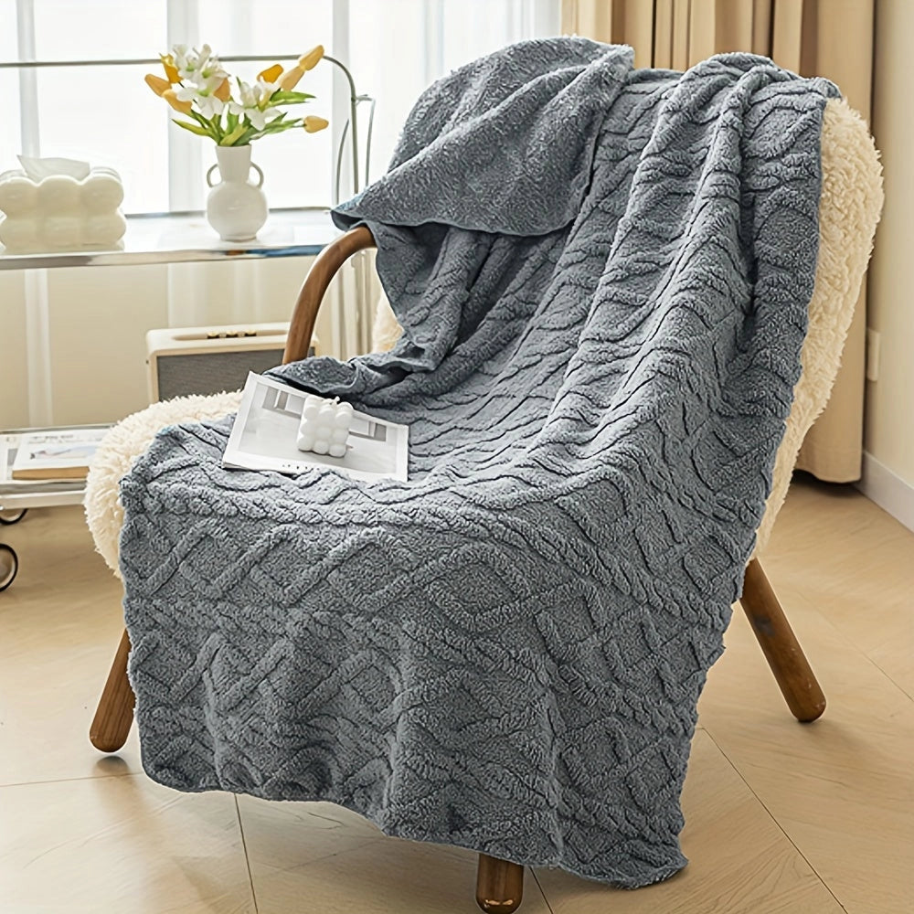 Luxurious cream geometric throw blanket elegantly draped over a plush armchair, with a soft and comfortable texture. The cozy setting includes a grey-toned wooden floor and a potted plant nearby, enhancing the room's inviting ambiance.