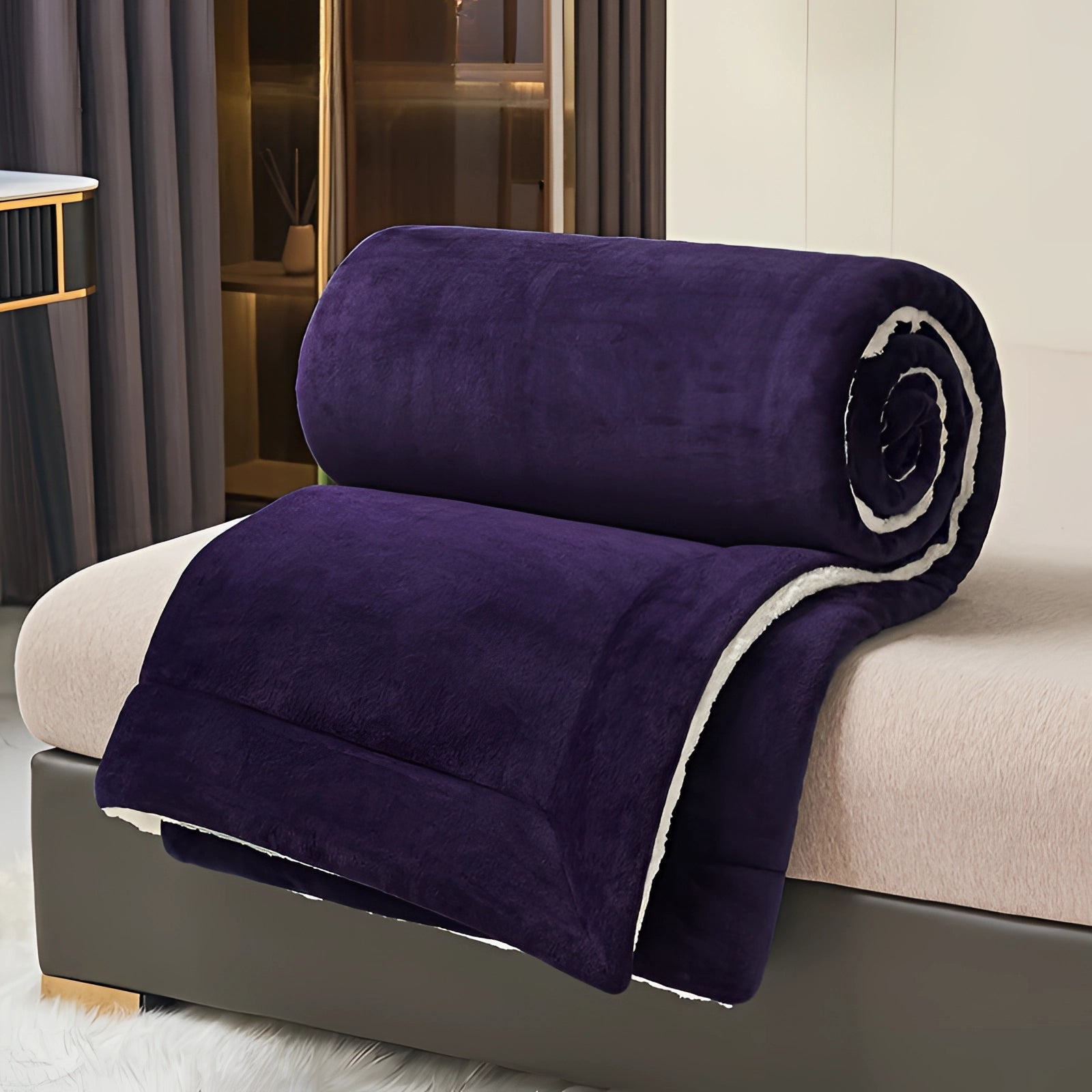 Luxurious deep purple velvet blanket with plush Sherpa lining draped over a rectangular studio couch, showcasing its rich violet hue and soft texture, ideal for comfort and style in a sophisticated living space.