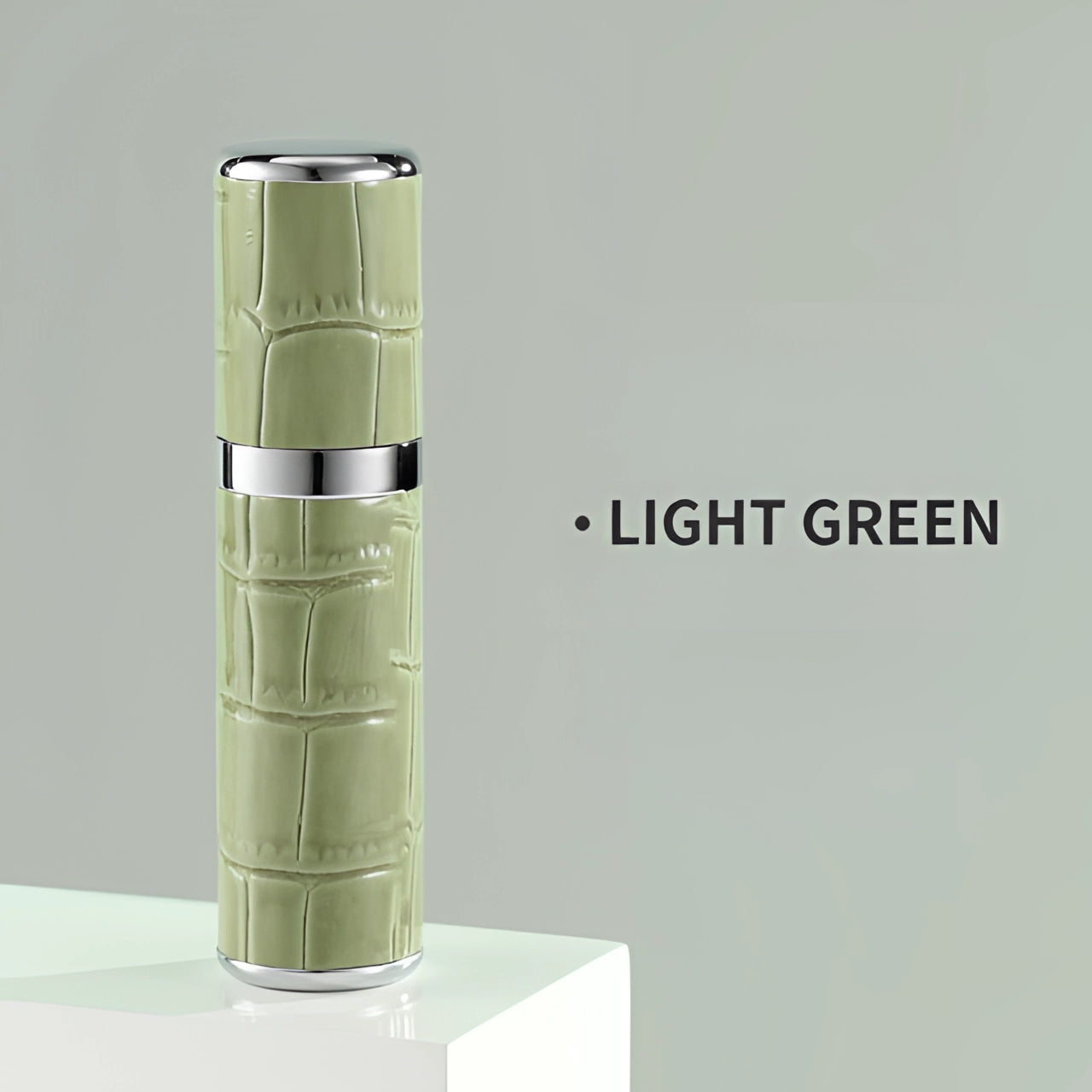 
A luxury designer lipstick with a crocodile skin texture in a light green shade, featuring a sleek cylindrical metal casing.