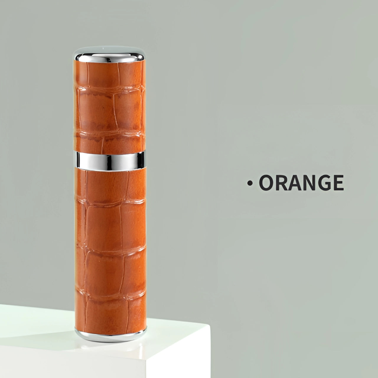 Luxury designer lipstick with a unique crocodile skin texture in a vibrant orange shade, featuring a sleek cylindrical metallic casing.