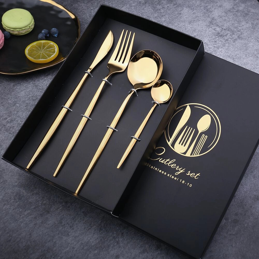 Elegant luxury gold cutlery set including forks, knives, and spoons on a white plate, showcasing modern design and sophisticated tableware.