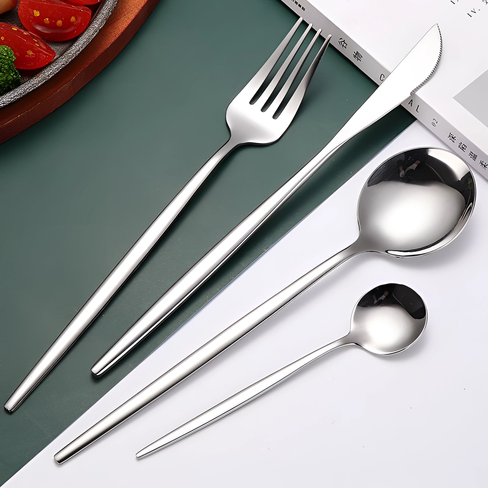 
A luxury silver cutlery set featuring elegantly designed forks, knives, and spoons, showcasing a modern and sophisticated style suitable for enhancing any dining experience. The set is beautifully arranged on a table setting.