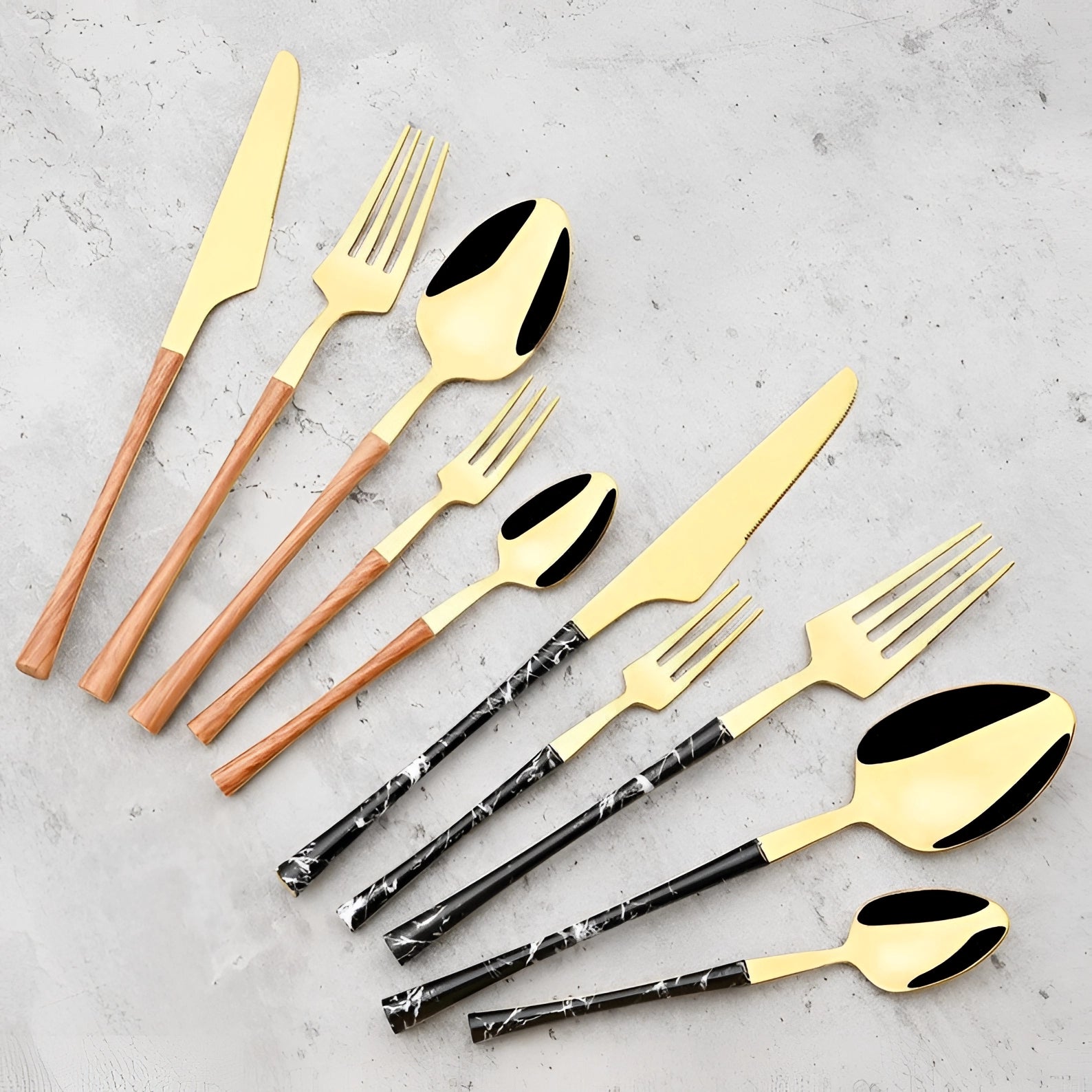 Luxury gold marble handle cutlery set featuring sleek designer flatware with metal finishes, displayed on a wooden tabletop.