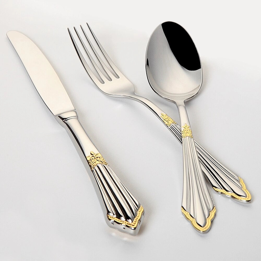 Luxury gold and silver cutlery set displayed elegantly on a table, featuring a fork alongside other utensils, ideal for weddings and special events; complementing serveware includes plates.