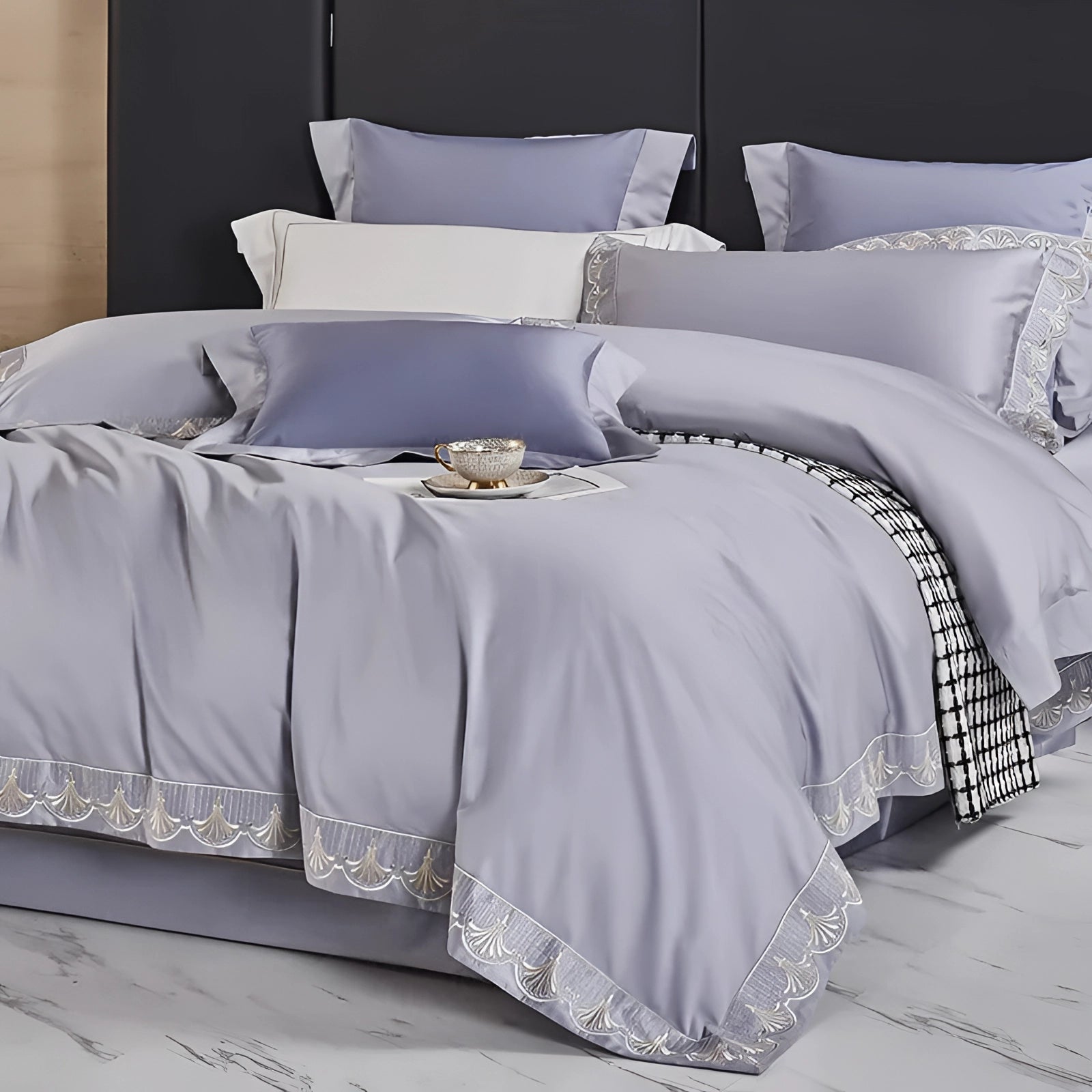 Luxurious gray cotton bedding set including a silk satin bedspread and matching pillow shams displayed on a neatly made bed, showcasing the smooth texture and elegant appearance in a stylish bedroom setting.