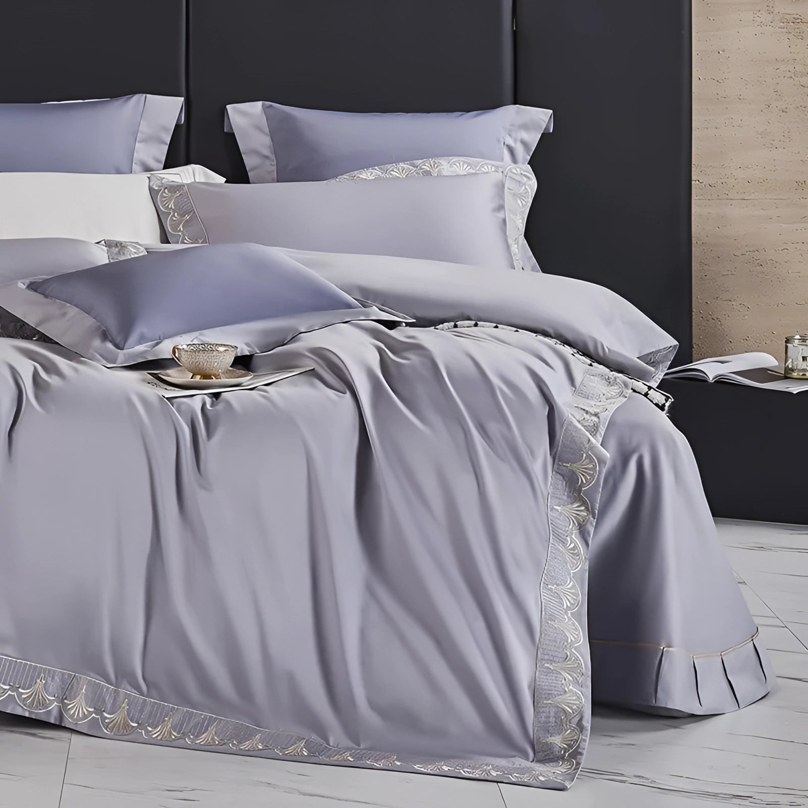 Luxury gray cotton bedding set featuring a silk satin bedspread and matching pillow shams, elegantly arranged on a wooden floor.