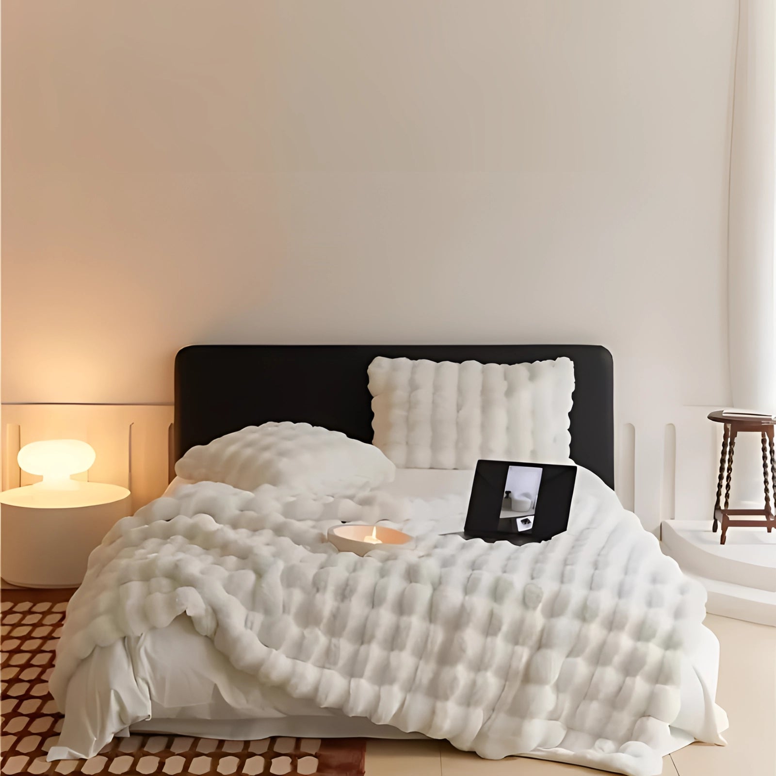 Luxury gray faux fur blanket draped over a bed in a cozy bedroom setting, with pillows and a wooden bed frame, enhanced by soft lighting and a lamp, adding a plush and stylish touch to the room's interior decor.