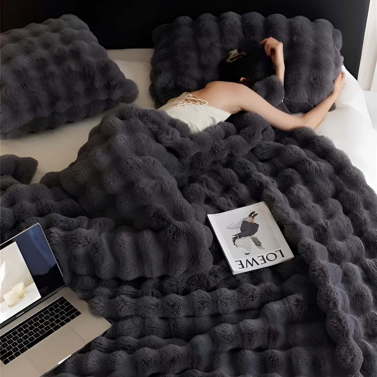 Luxurious dark gray faux fur blanket draped elegantly over a surface, showcasing its plush and soft texture, ideal for home decor.