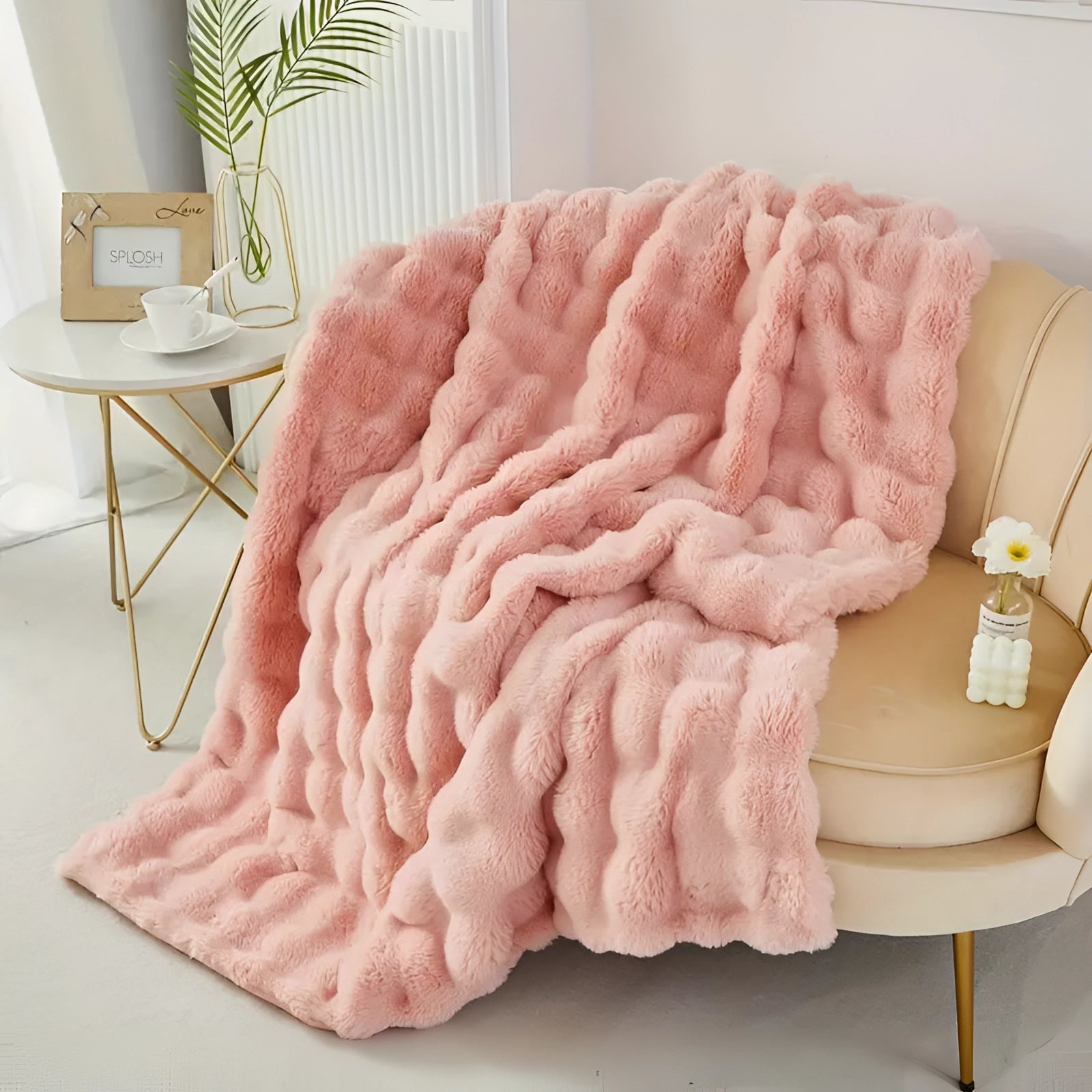 Luxury handmade chunky knit weighted blanket draped over a comfortable couch, with a wooden table and a potted plant nearby on a hardwood floor.