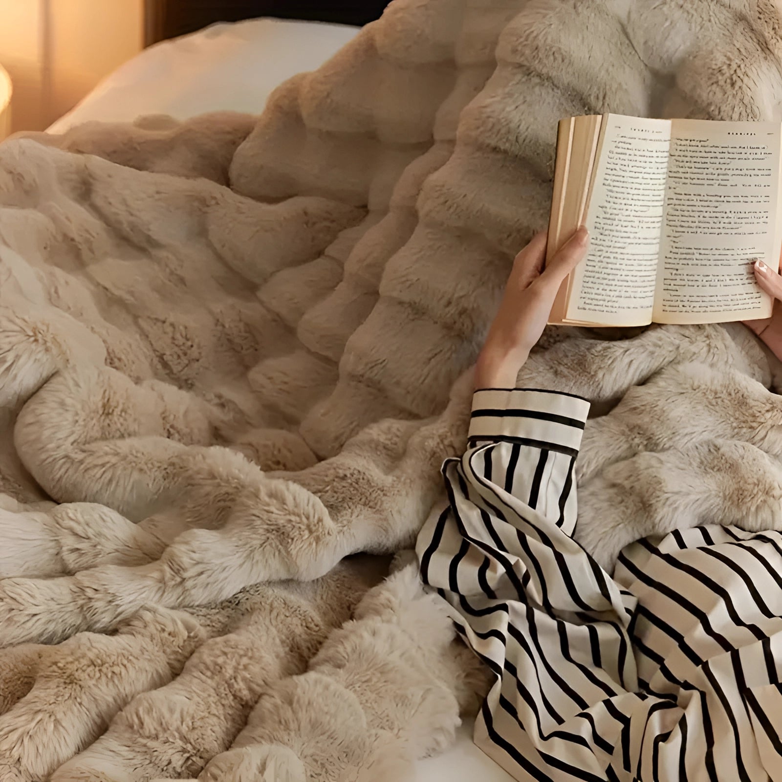 Luxury handmade chunky knit weighted blanket in beige, draped over a wooden surface, showcasing its thick, intricately woven pattern and cozy texture.