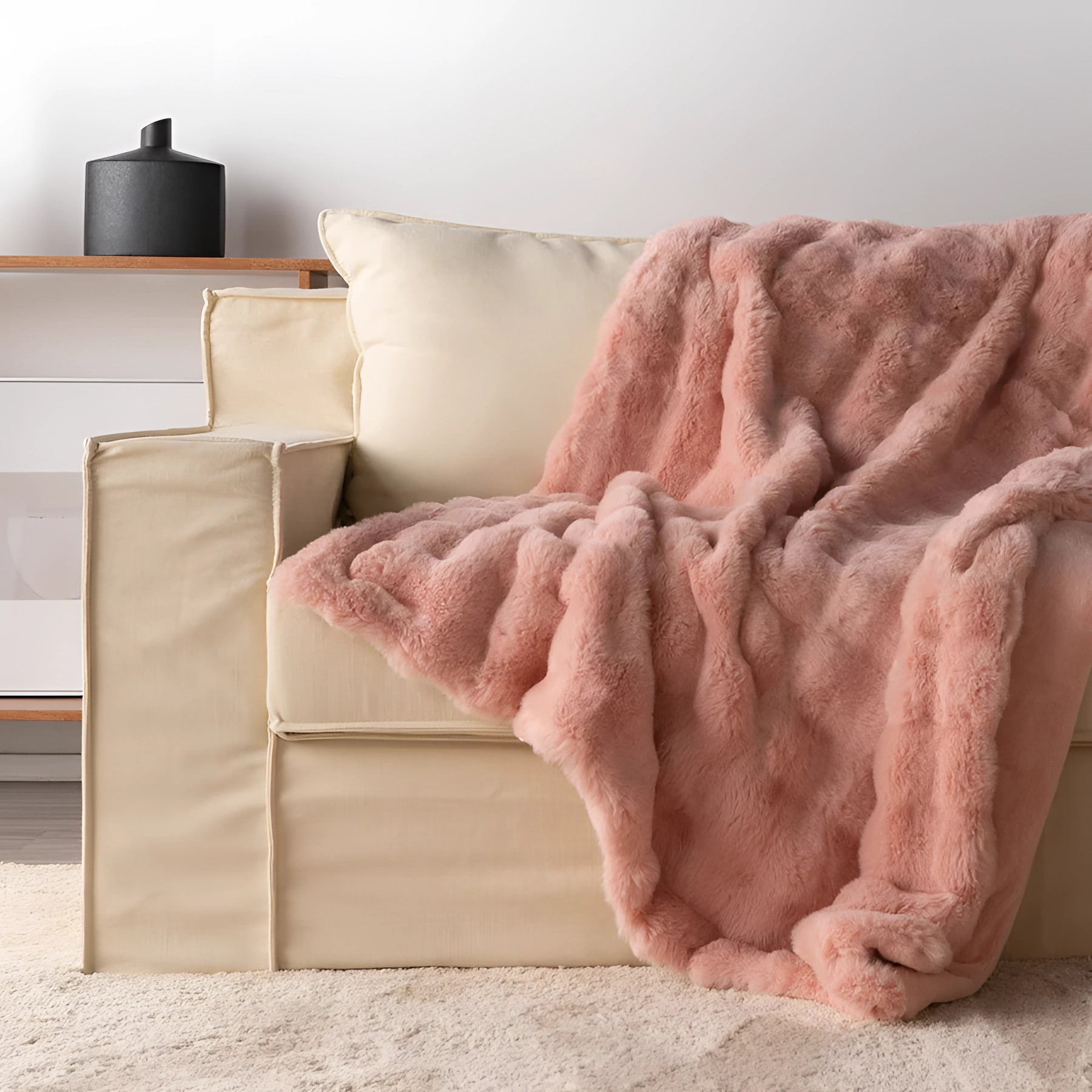 Luxury handmade chunky knit weighted blanket in rose blush color draped over a beige couch in a living room with hardwood flooring, measuring 160x200cm.