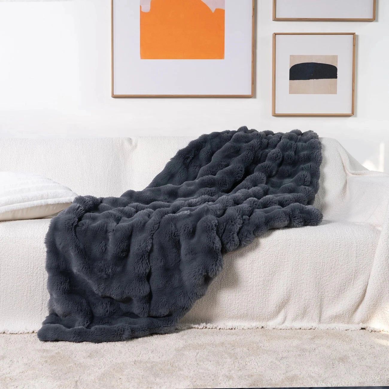 Luxury handmade chunky knit weighted blanket in a shadow grey color, measuring 160x200cm, draped elegantly over a wooden floor, showcasing its cozy and comforting texture.