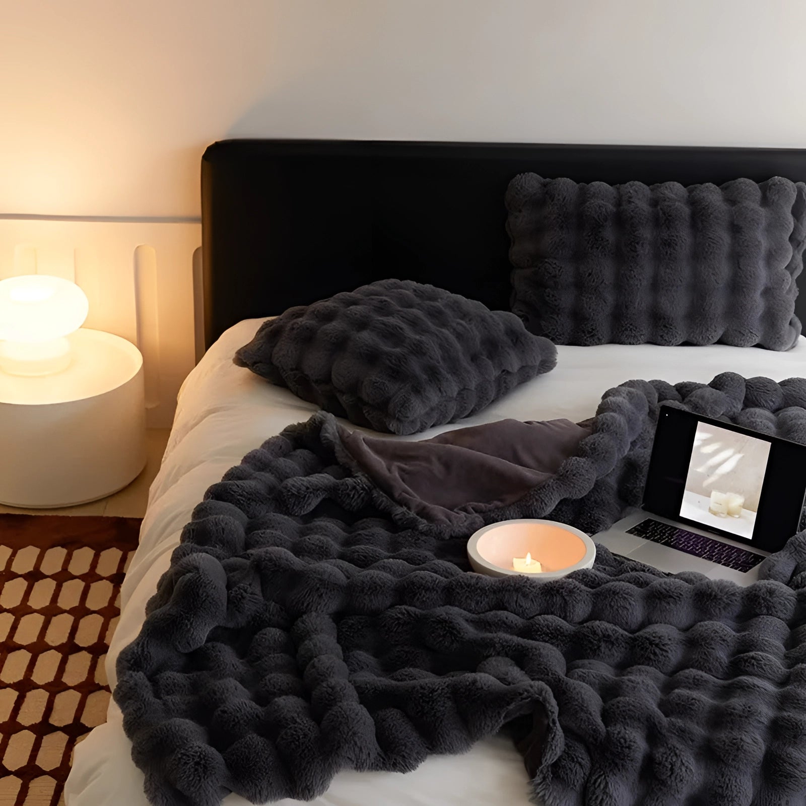 Luxury handmade chunky knit weighted blanket in a cozy designer throw style, displayed draped over furniture in a warm, inviting setting with neutral tones.