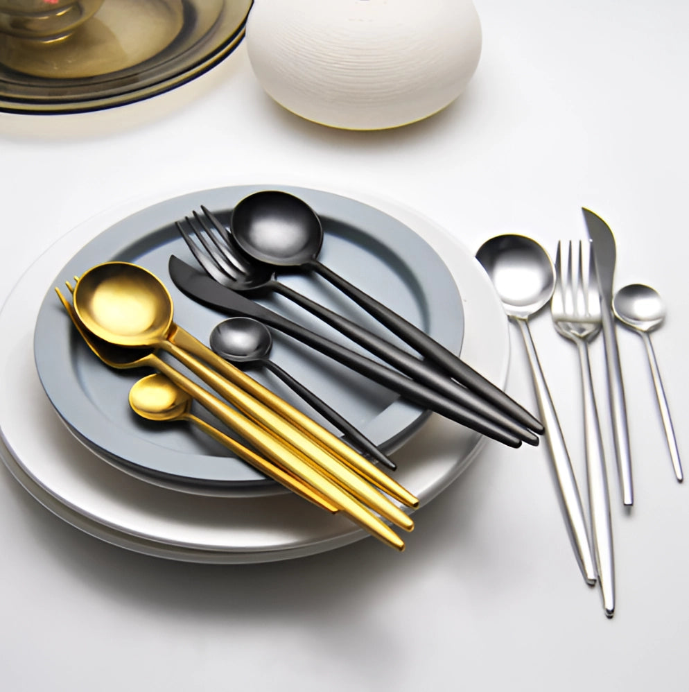 Luxury metallic finish cutlery set comprising a knife, fork, and spoon displayed on a wooden circular plate, highlighting their sleek and stylish design, perfect for enhancing any dining experience.