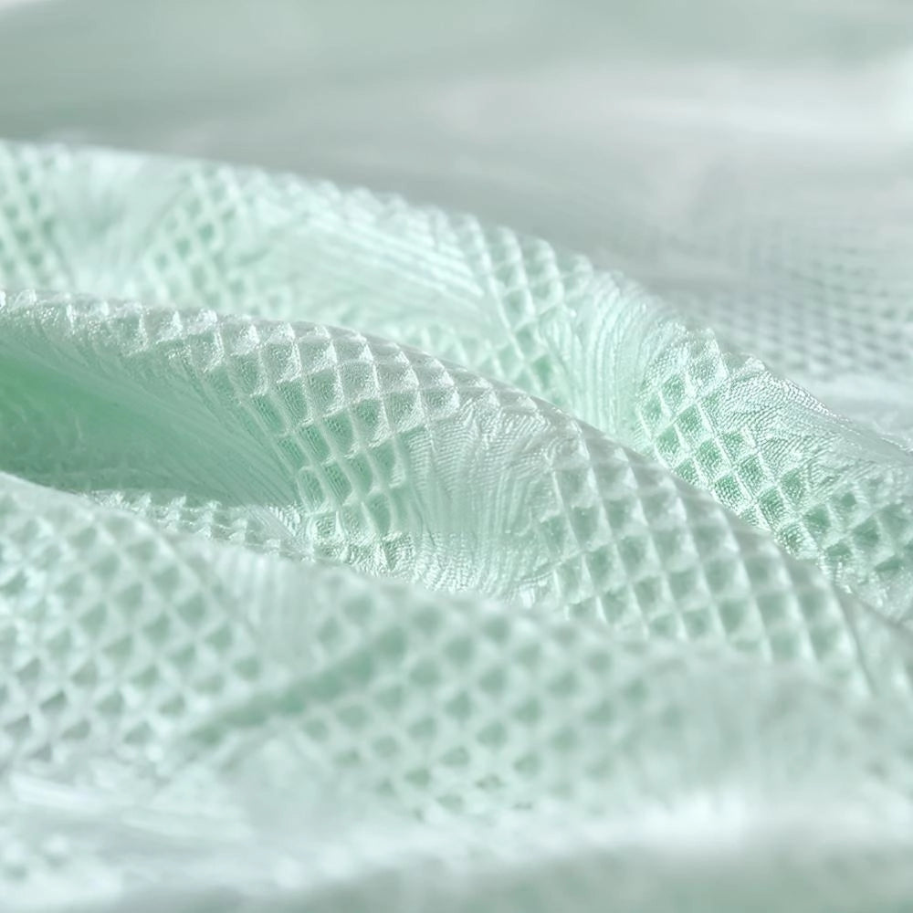 Luxurious mint green textured blanket with an elegant pattern, ideal for summer use.