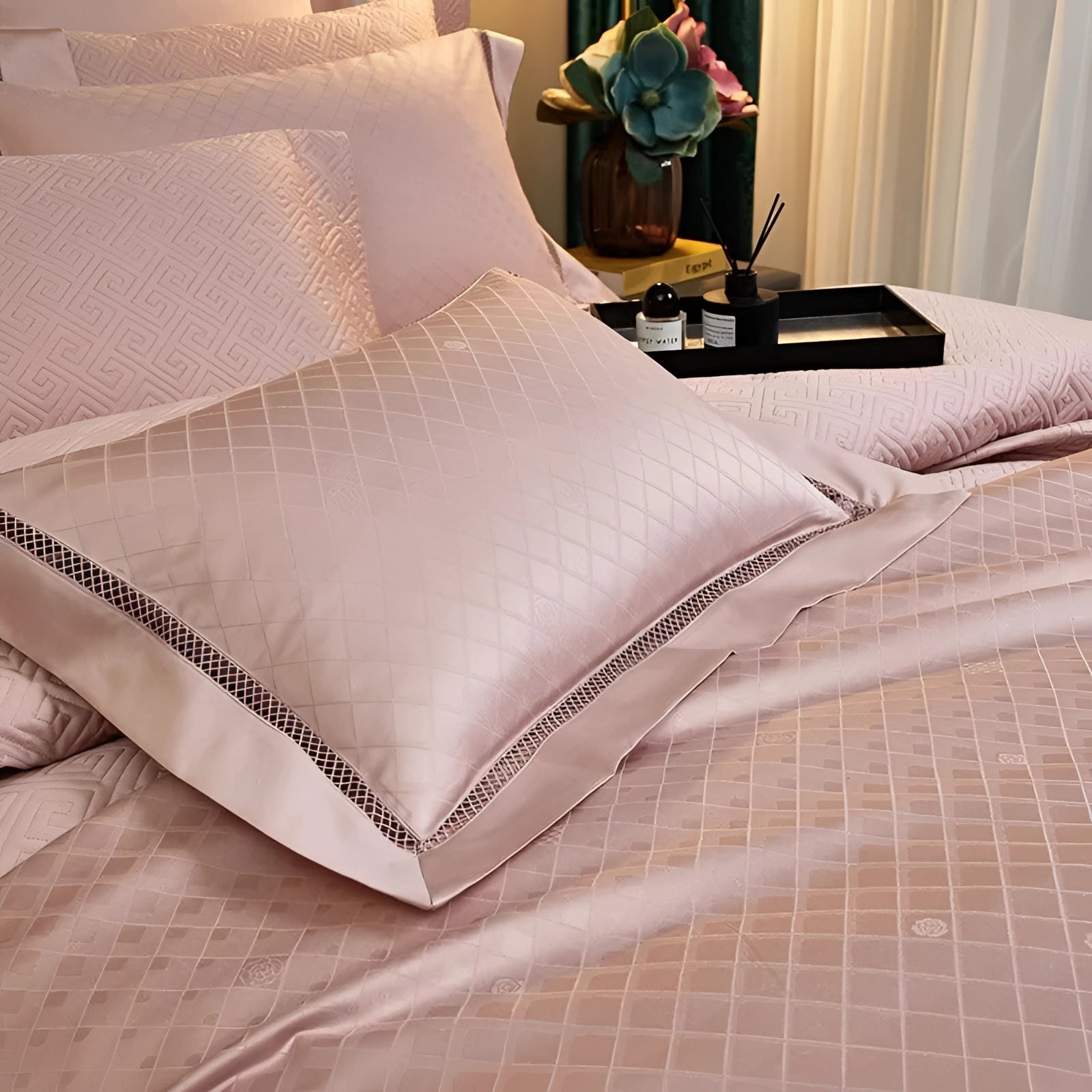 Luxury pink satin bedding set featuring a geometric duvet and pillowcases on a wooden bed frame with a comfortable and elegant appearance.