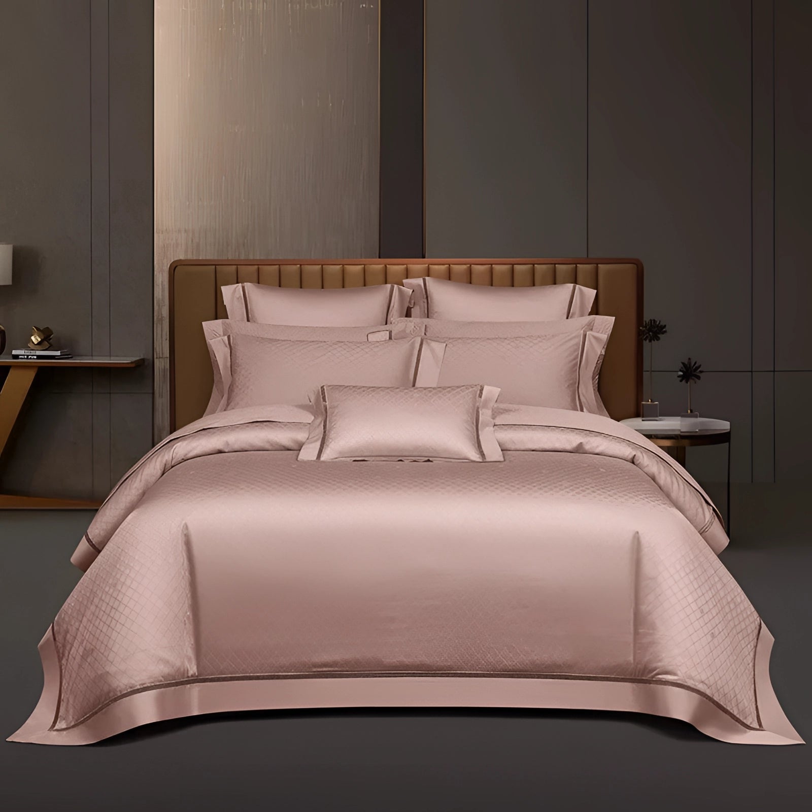 Luxury pink satin bedding set with geometric duvet and pillowcases in a king size, arranged on a wooden bed frame.