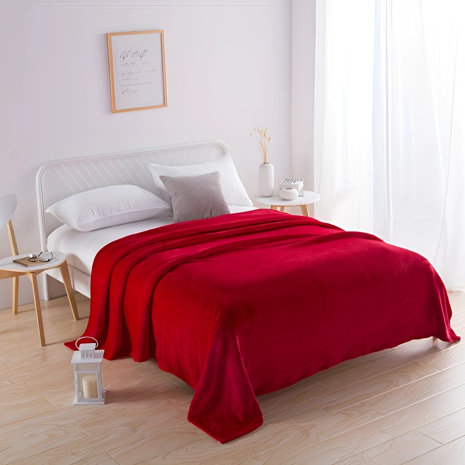 Luxury red velvet blanket draped over a hardwood floor in a cozy interior setting, with a wooden chair nearby.