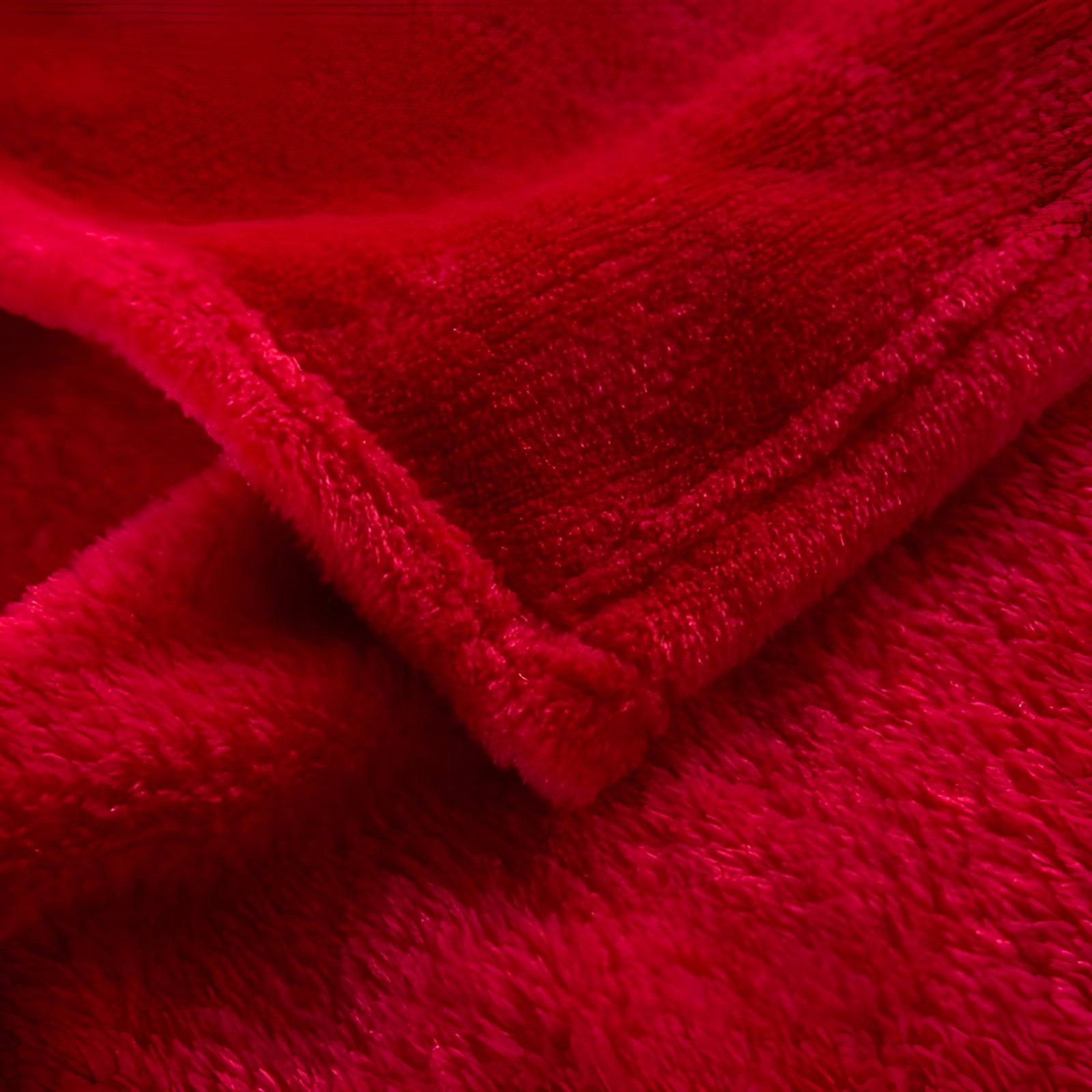 Luxury red velvet blanket with a rich carmine hue, showcasing a soft and cozy texture, draped elegantly to highlight its premium quality.