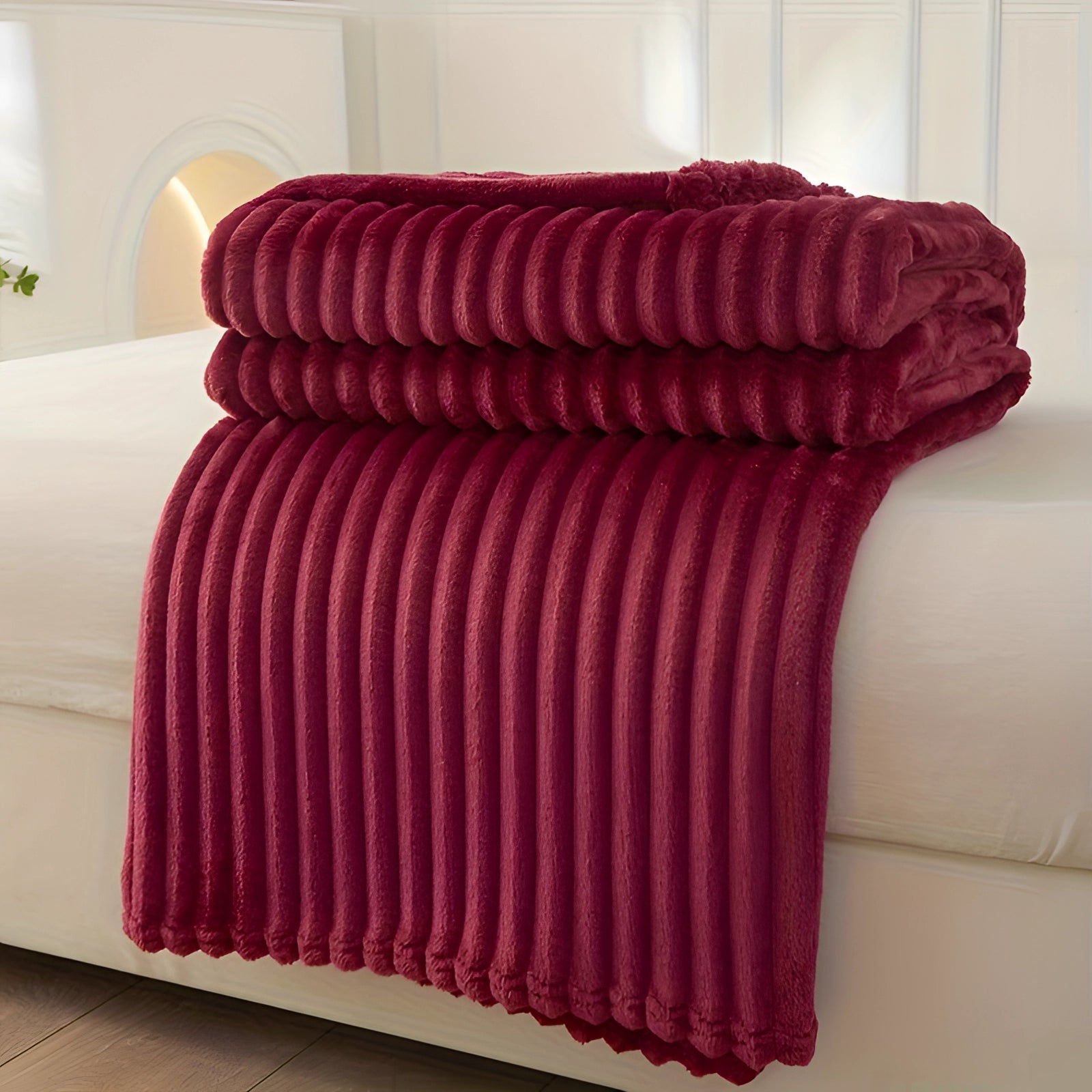 Luxurious red velvet throw blanket draped over a couch, featuring a ribbed texture and measuring 200 x 230cm, adding a cozy and decorative accent to the furniture.