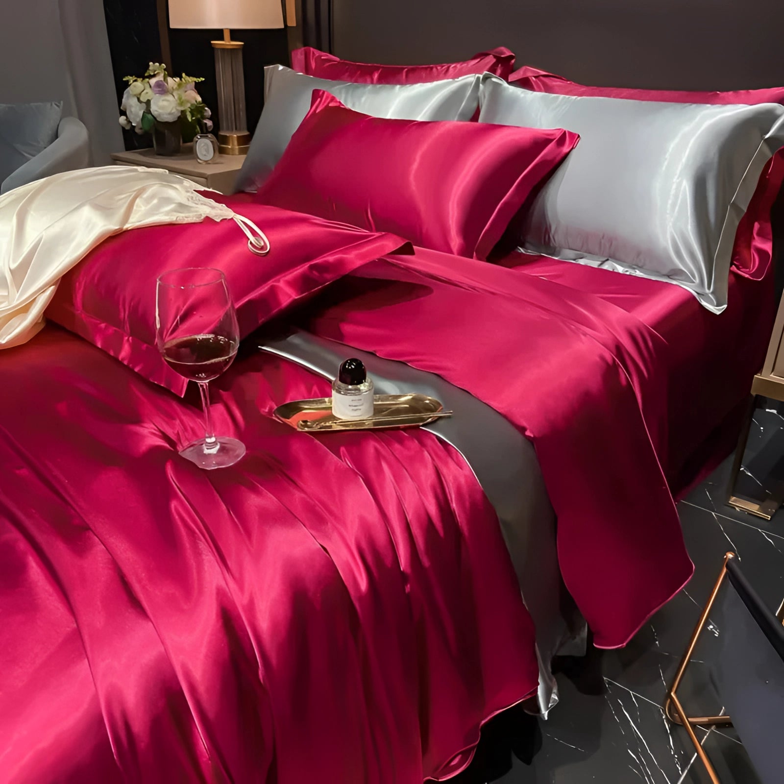 Luxury silk bedding set in a rich wine red color, featuring copper satin sheets and elegant pillowcases on a neatly made bed with a stylish bed frame, exuding comfort and sophistication.